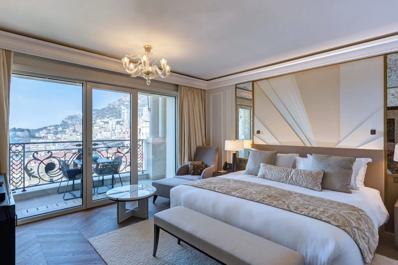 Exclusive Room with harbour view at Hôtel de Paris Monte-Carlo: the bed, an armchair and glass doors to a balcony over the town