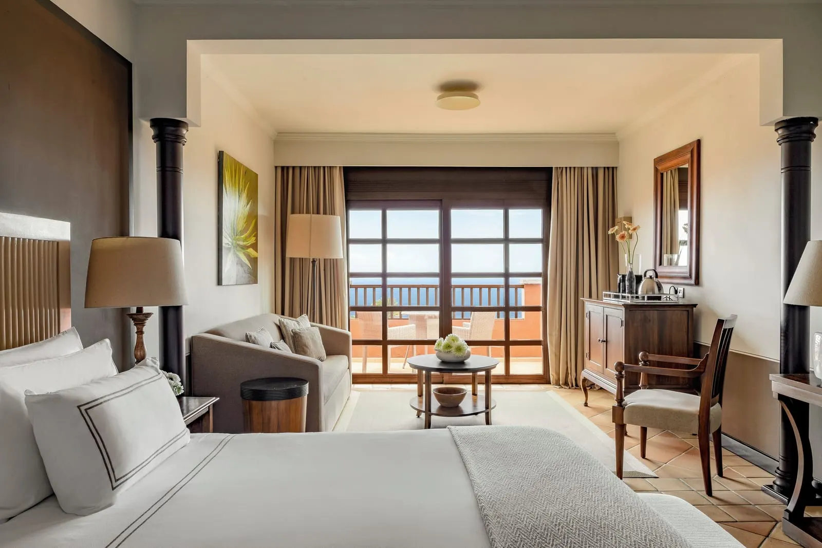 Singular Junior Suite Sea View with Panoramic Terrace at Hacienda del Conde: a sofa, a desk and a table by the terrace doors