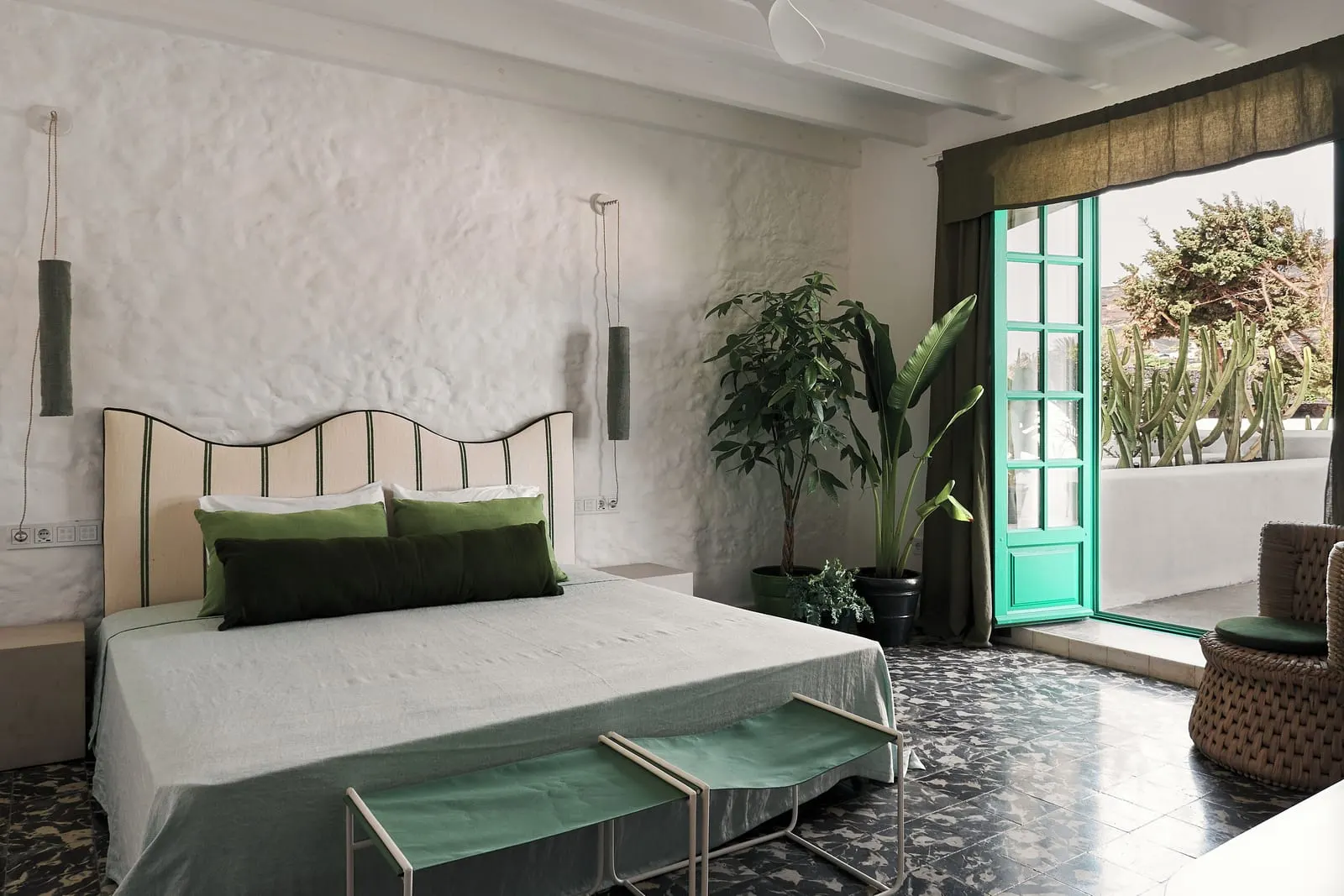Superior Room with Terrace à l'Hotel César Lanzarote : un lit avec une tête de lit festonnée près d'une porte verte ouverte sur la terrasse