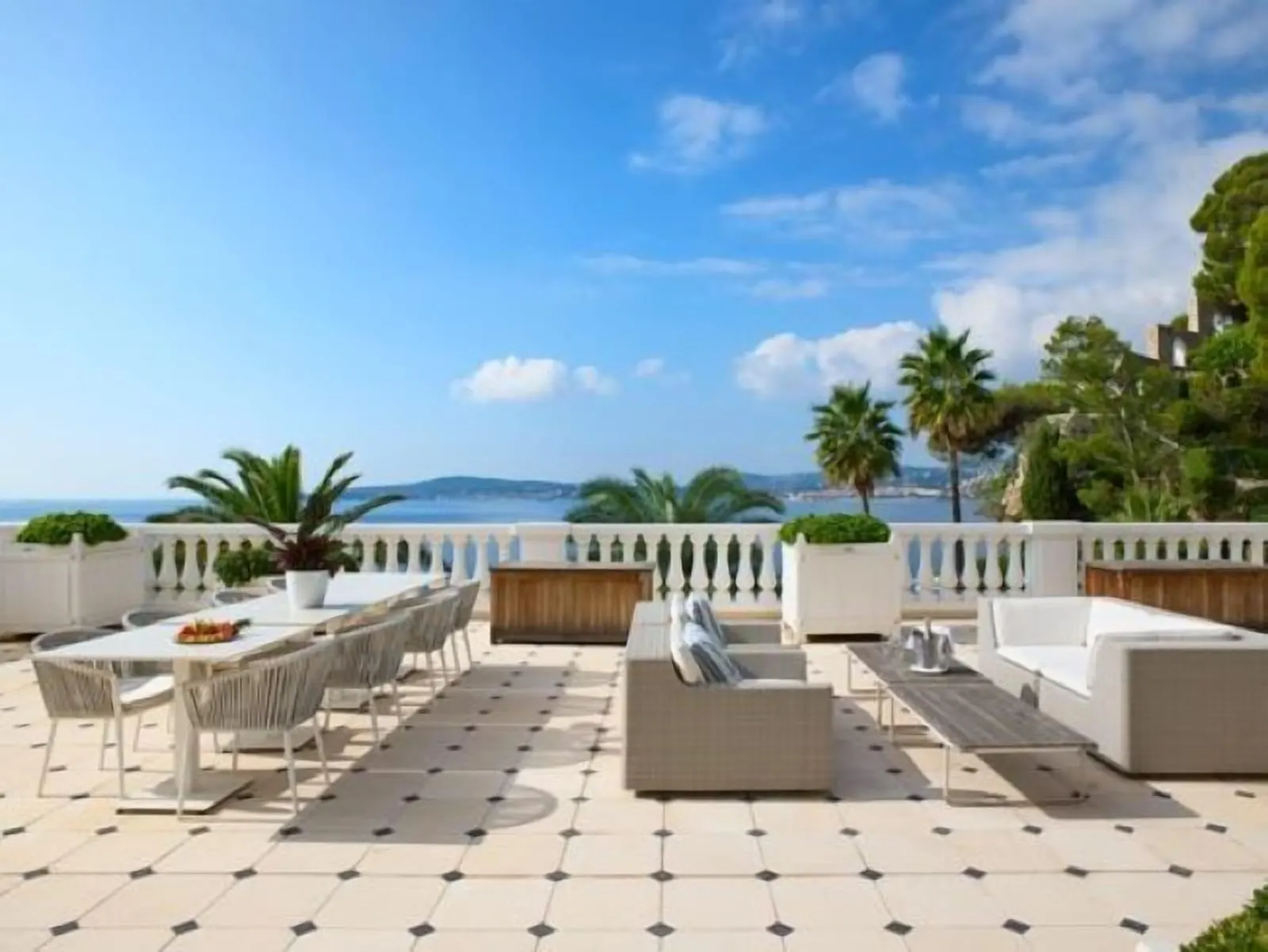 Suite 310 at Cap Estel: the terrace with a long dining table and sofas above the sea