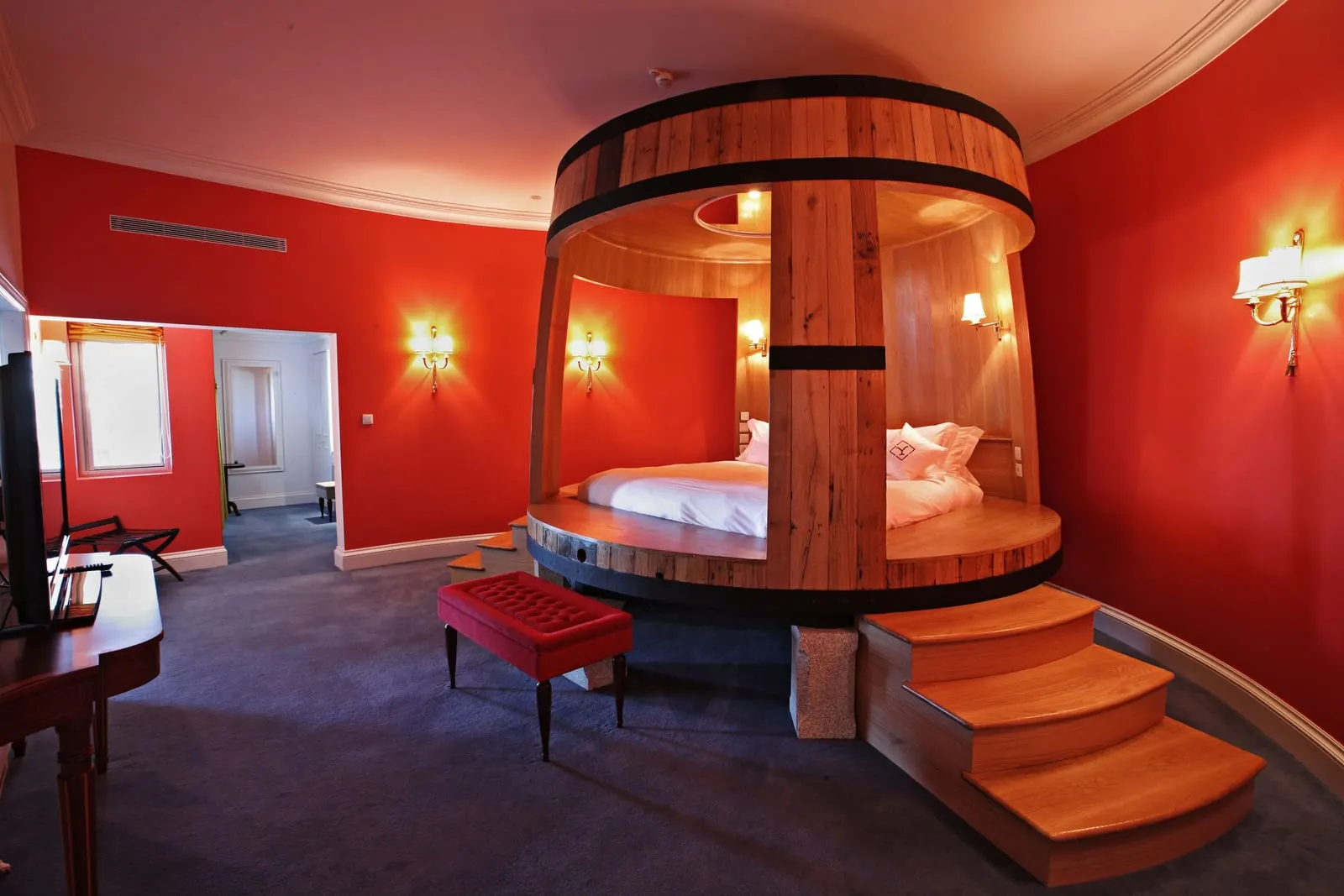 Master Suite Garden at The Yeatman: a round bed inside a giant wooden barrel, reached by steps, in a red bedroom