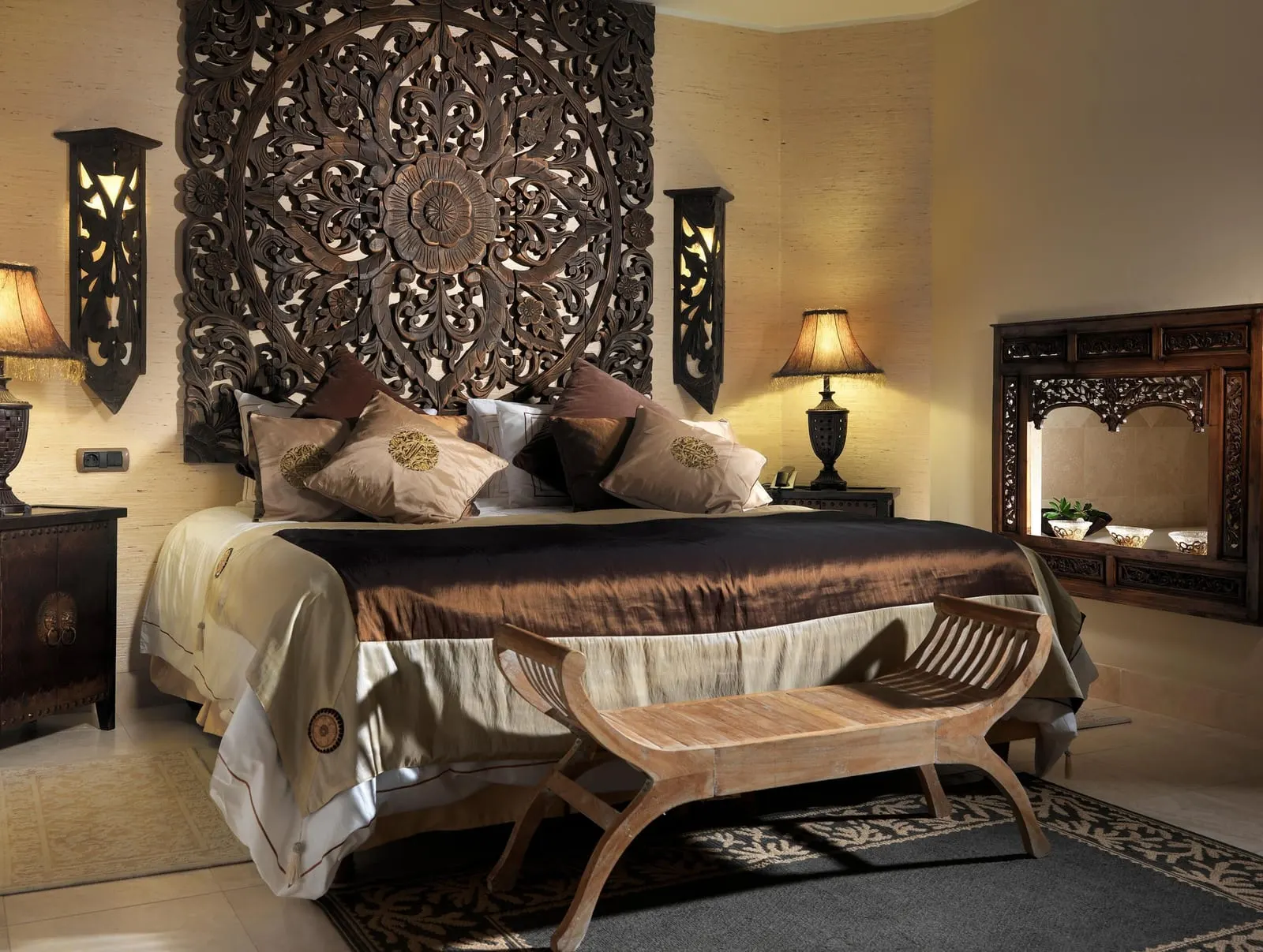 Gran Majestic Villa at Royal Garden Villas: a bed under a carved wooden headboard, with a bench at its foot