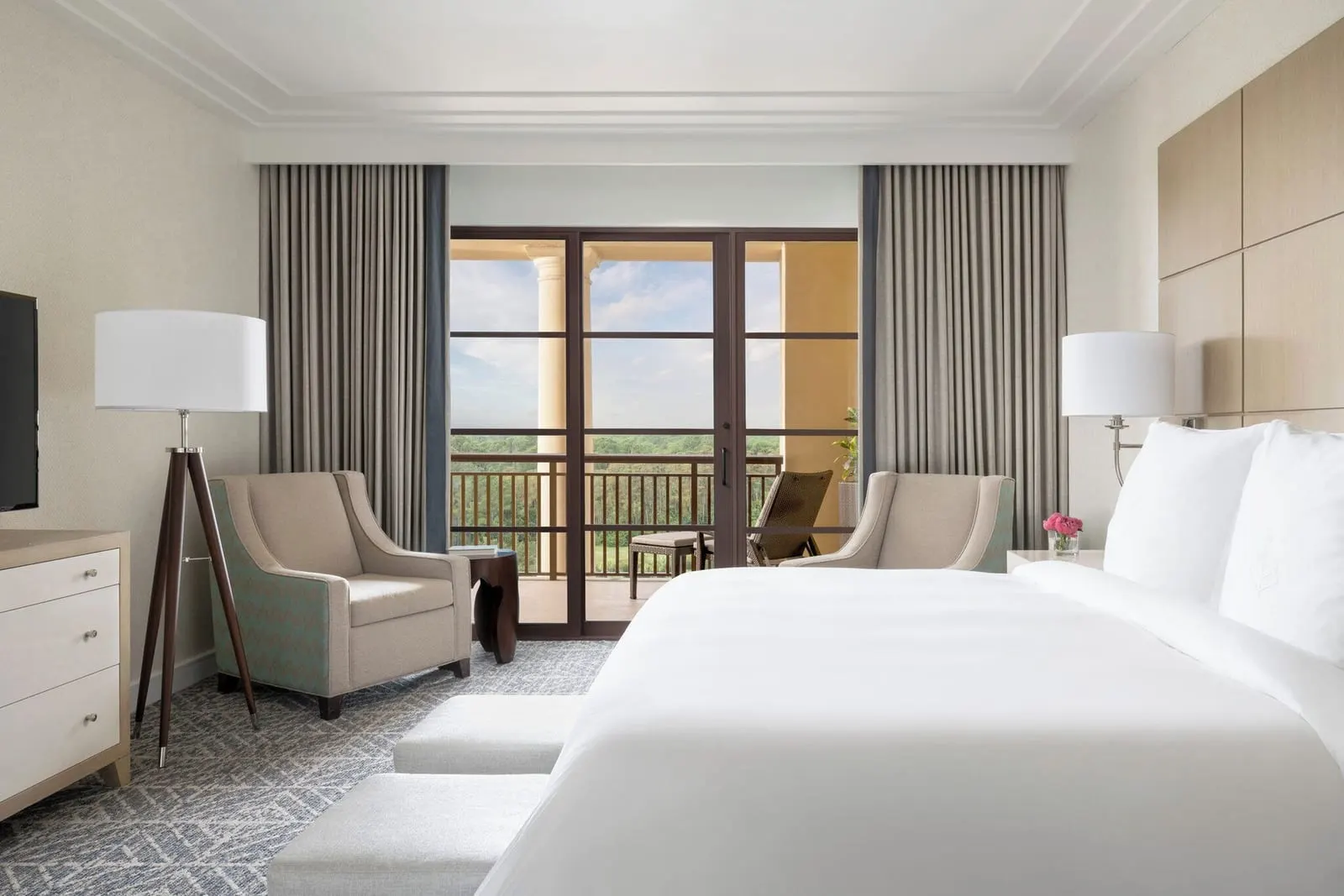 Park View Suite im Four Seasons Resort Orlando at Walt Disney World Resort: das Schlafzimmer, mit einem Kingsize-Bett, zwei Sesseln und Glastüren zur Terrasse