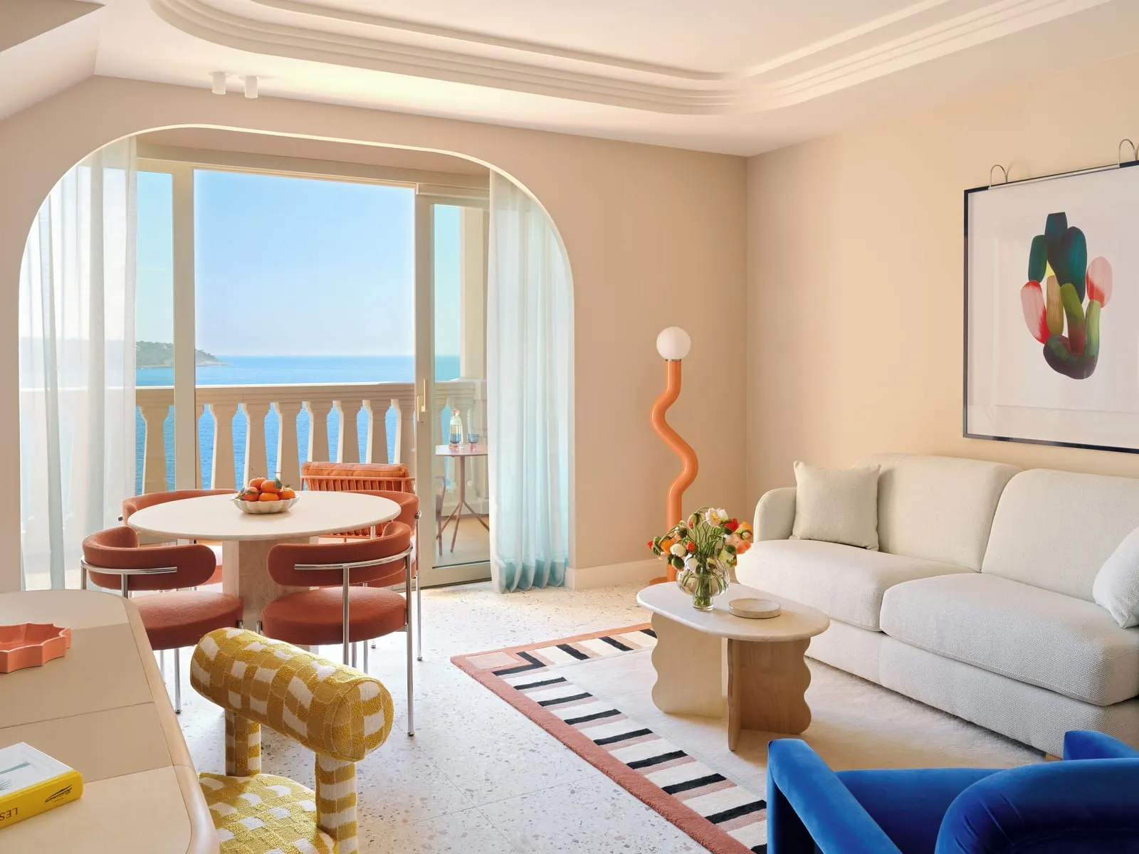 Duplex Suite with sea view at Monte-Carlo Bay Hotel & Resort: the living room with a sofa, a round table and doors to the terrace