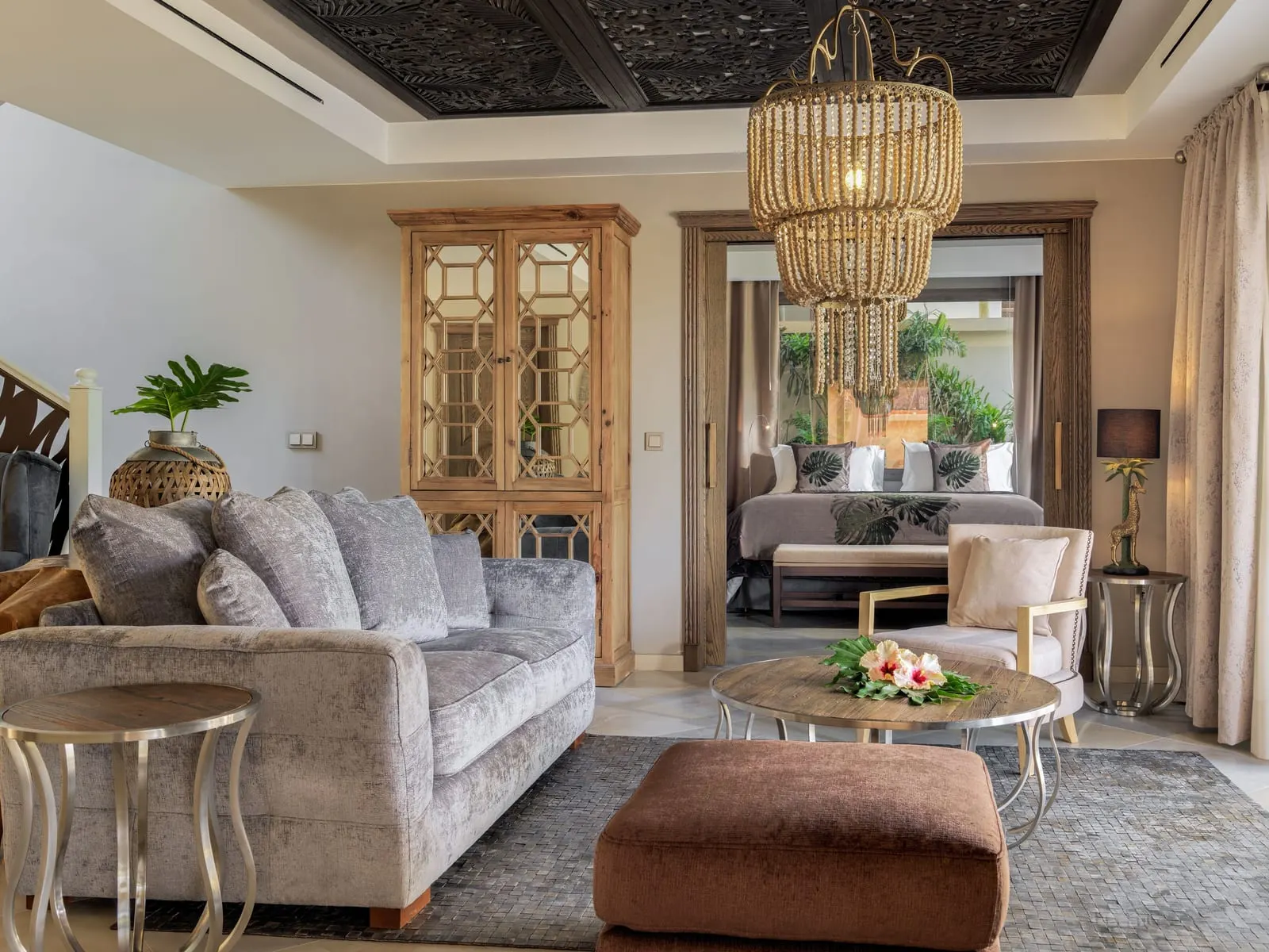 Three-bedroom Grand Pool Villa at Royal River: the living room, with a grey sofa and a bedroom through the doorway