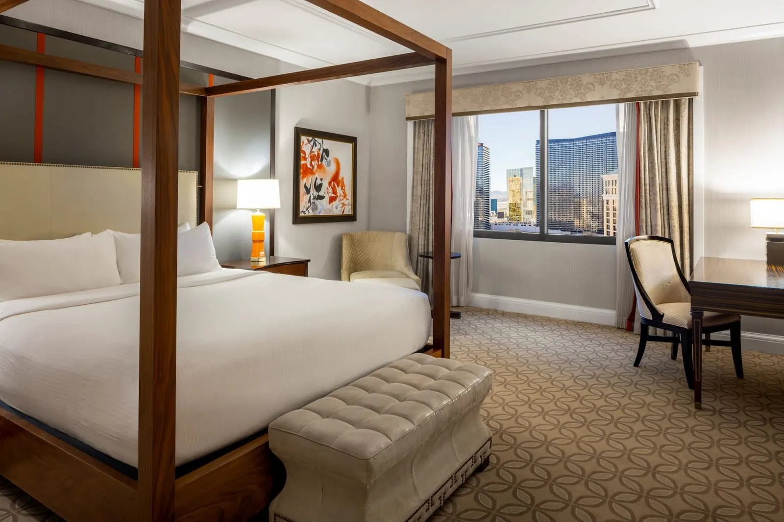 Palace Premium Suite im Caesars Palace: ein Kingsize-Pfostenbett mit einer gepolsterten Bank, ein Sessel und ein Schreibtisch am Fenster