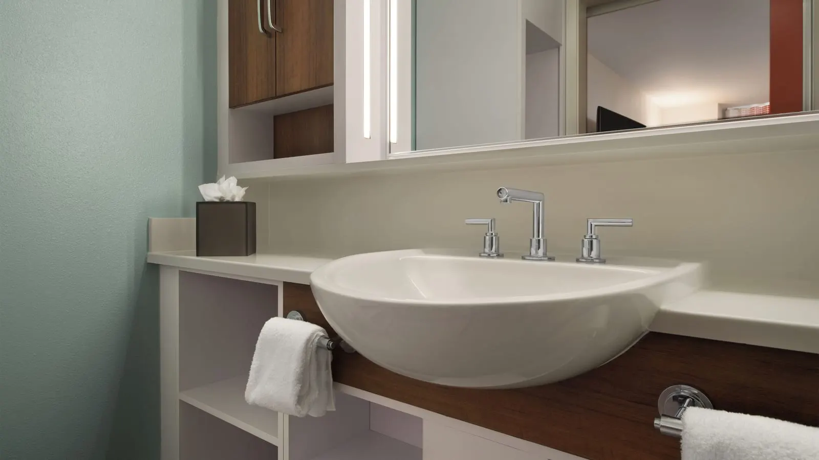 Standard Pool View room at Disney's Pop Century Resort: the washbasin on a long vanity, with a mirror, towel rails and wooden cupboards