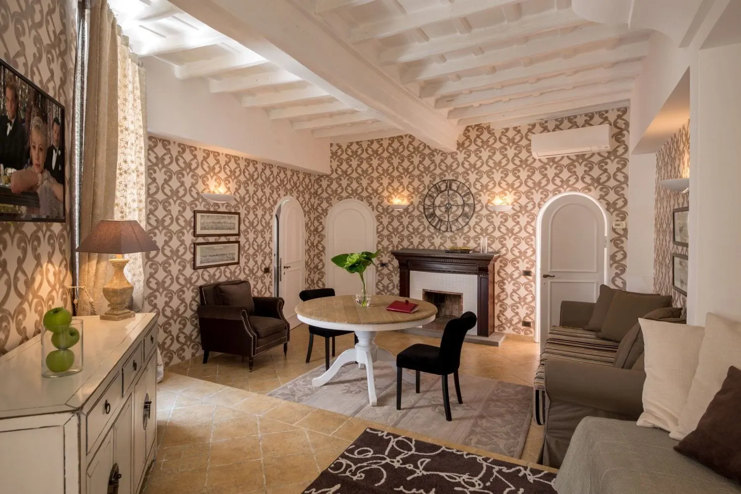 1 Bedroom Apartment at The Inn at the Roman Forum: a sitting room with a fireplace, a round table and a sofa