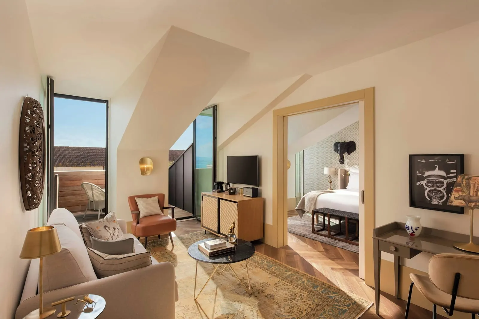 Signature Suite at The Ivens: the living room under a sloping ceiling, with a glass door to the terrace