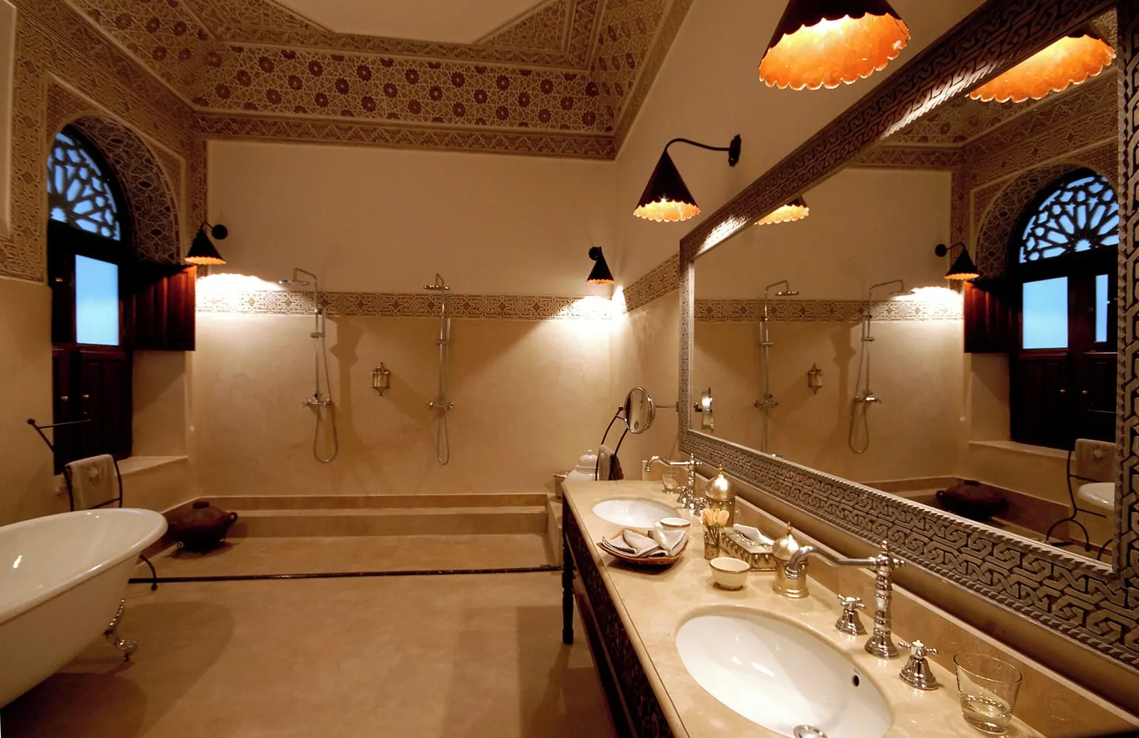 Room with Terrace at La Villa des Orangers: a bathroom with a freestanding bath, a double basin and a walk in shower under carved plaster.