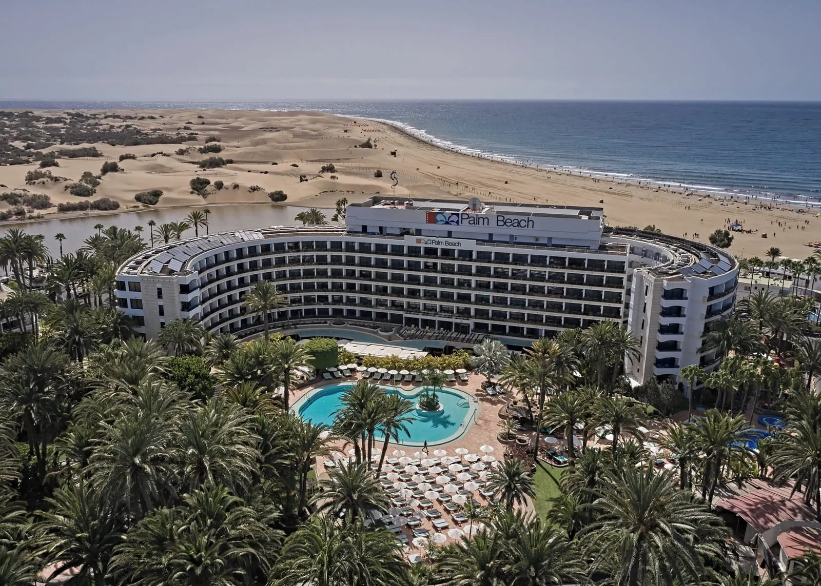 Seaside Palm Beach: The curved Seventies block between palms and dunes