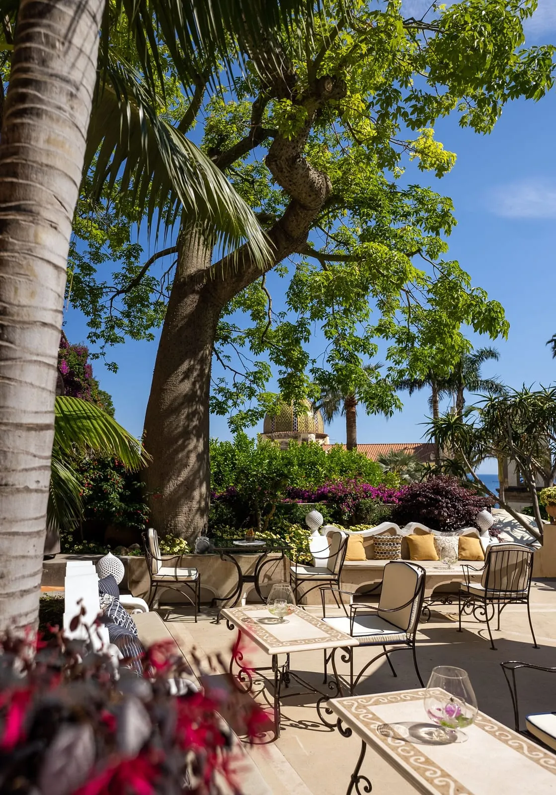 Palazzo Murat: Tables in the shade of the garden palms