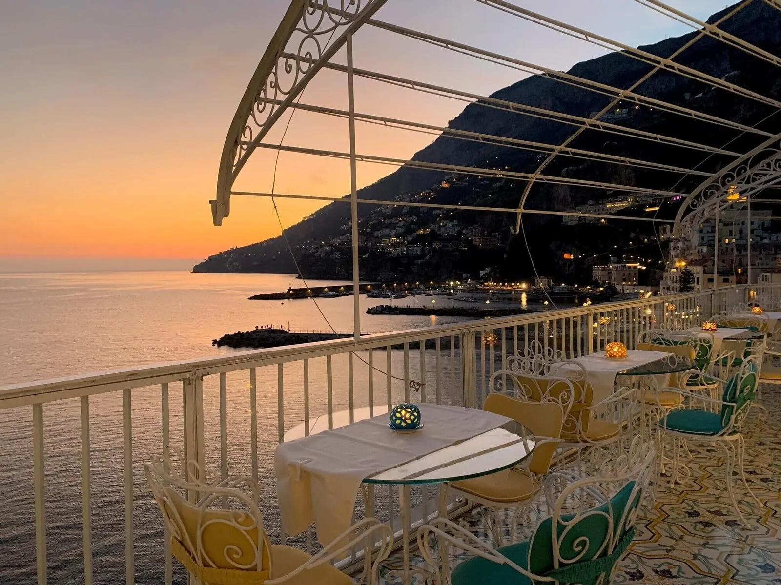 Hotel Marina Riviera: Terrace tables over the bay at dusk