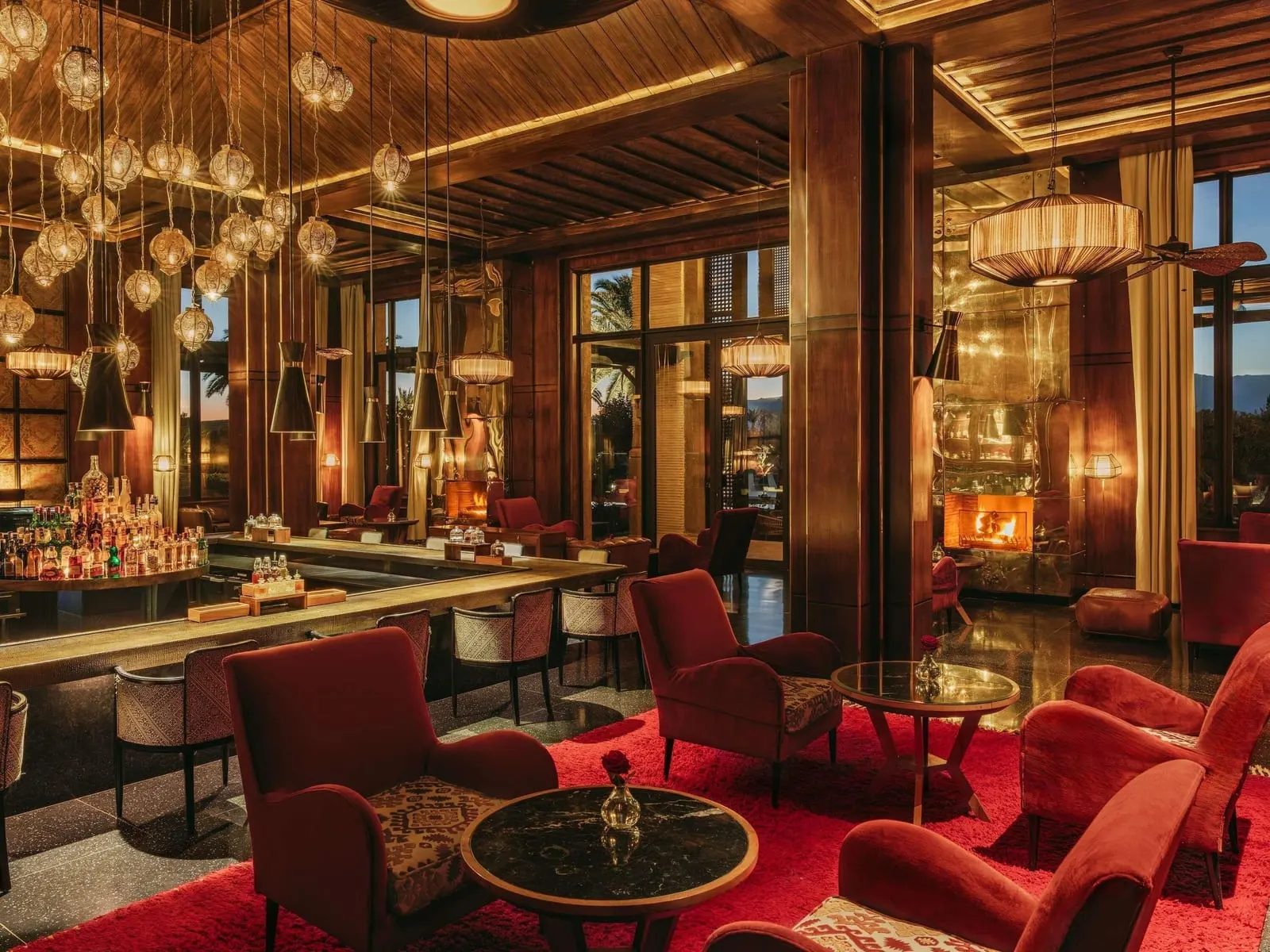 Fairmont Royal Palm Marrakech: A bar with red armchairs and a fireplace