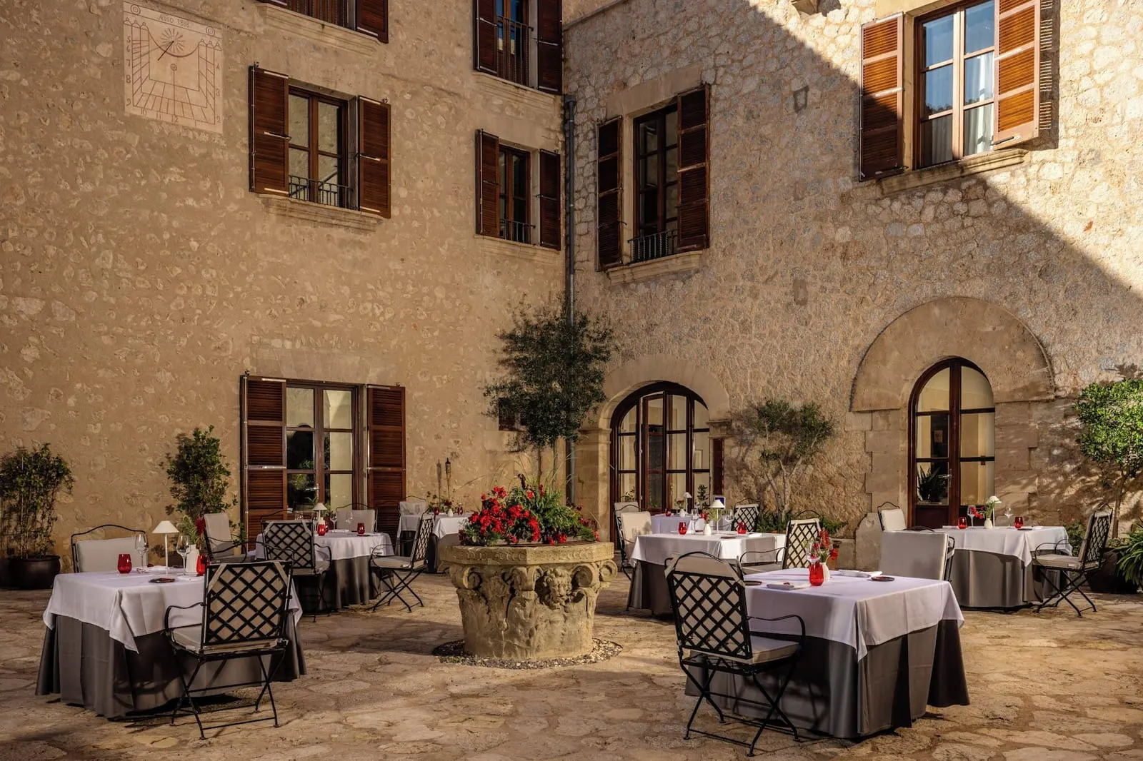 Castell Son Claret: Sa Clastra's courtyard tables below the 1888 sundial