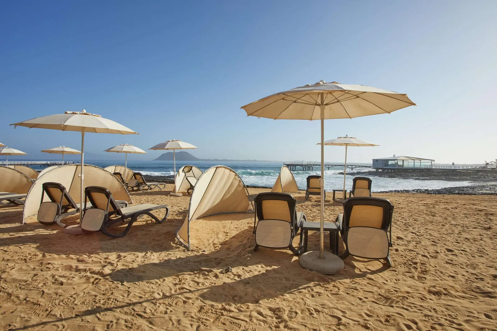 Secrets Bahía Real Resort & Spa: Sunbeds and shades on the sand below the hotel