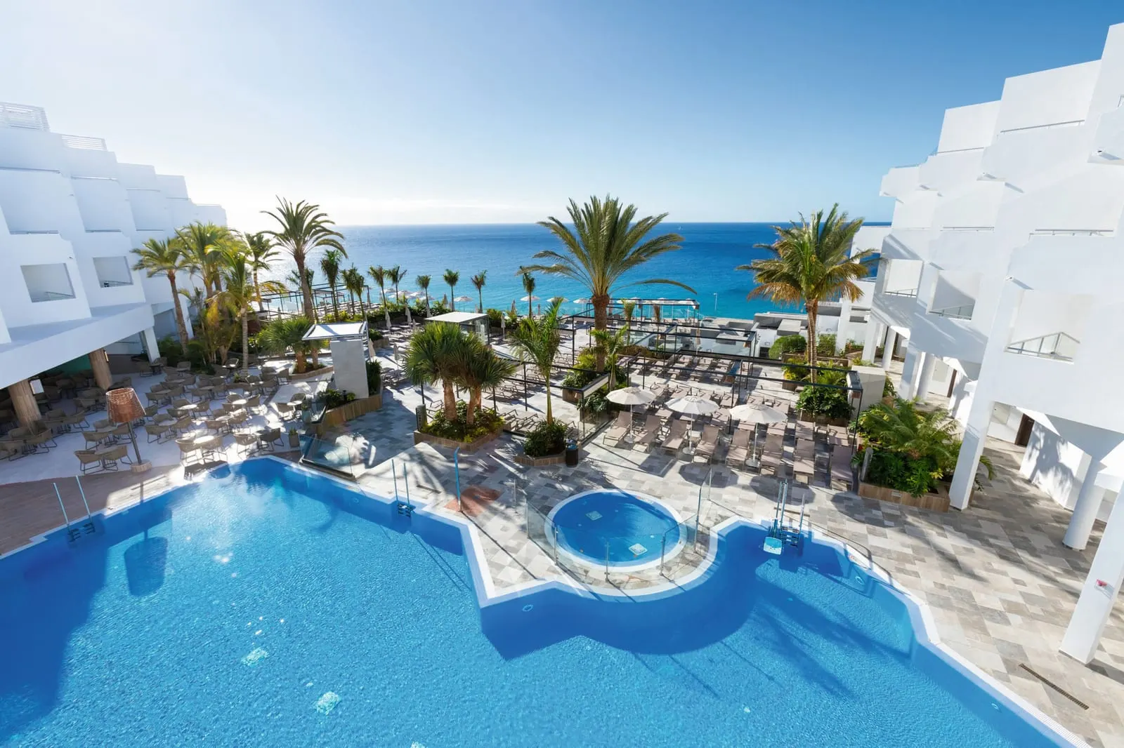 Hotel Riu Palace Jandia: The pool, with the sea beyond the palms