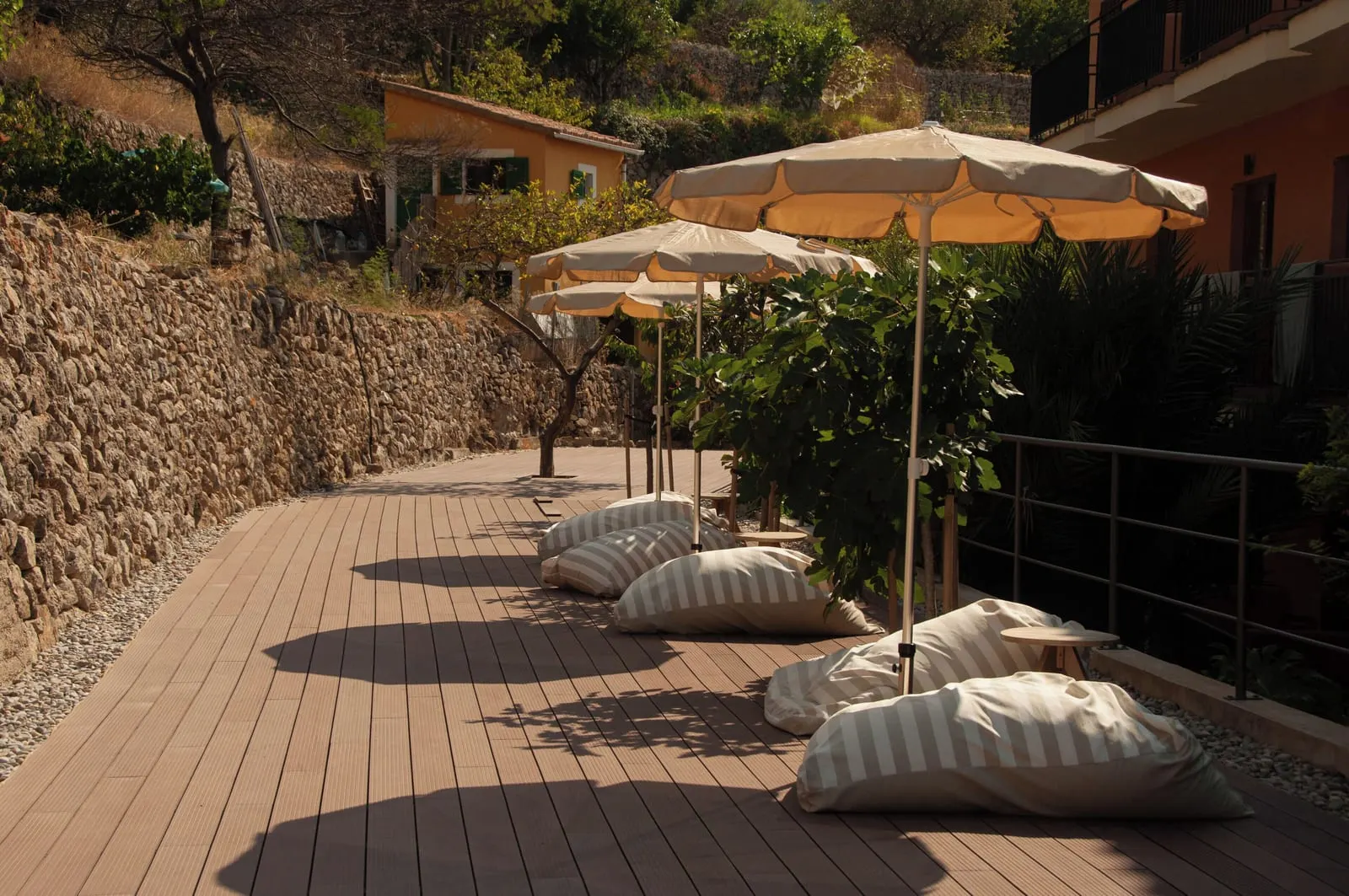 Maristel Hotel & Spa: Cushions and parasols on a deck by stone terraces