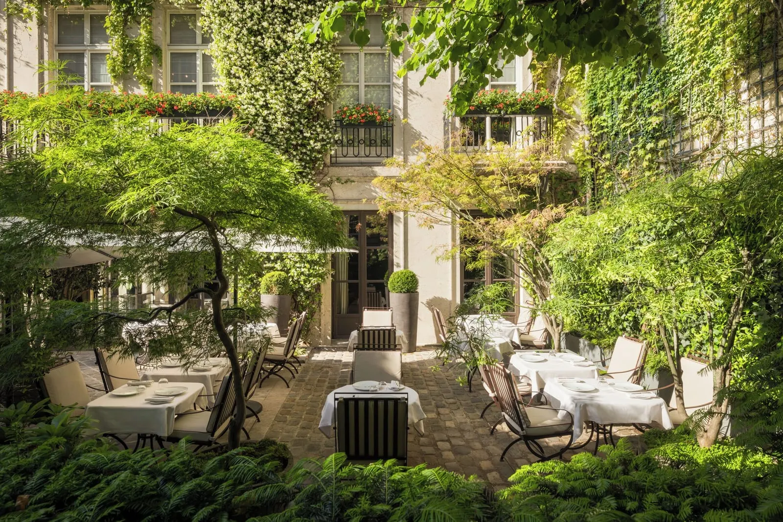 Le Pavillon de la Reine: Tables laid in the courtyard garden