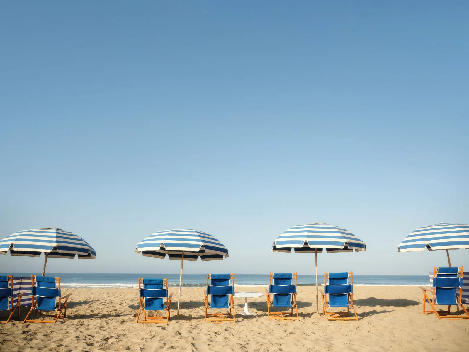 Shutters on the Beach: Striped umbrellas and chairs on the sand