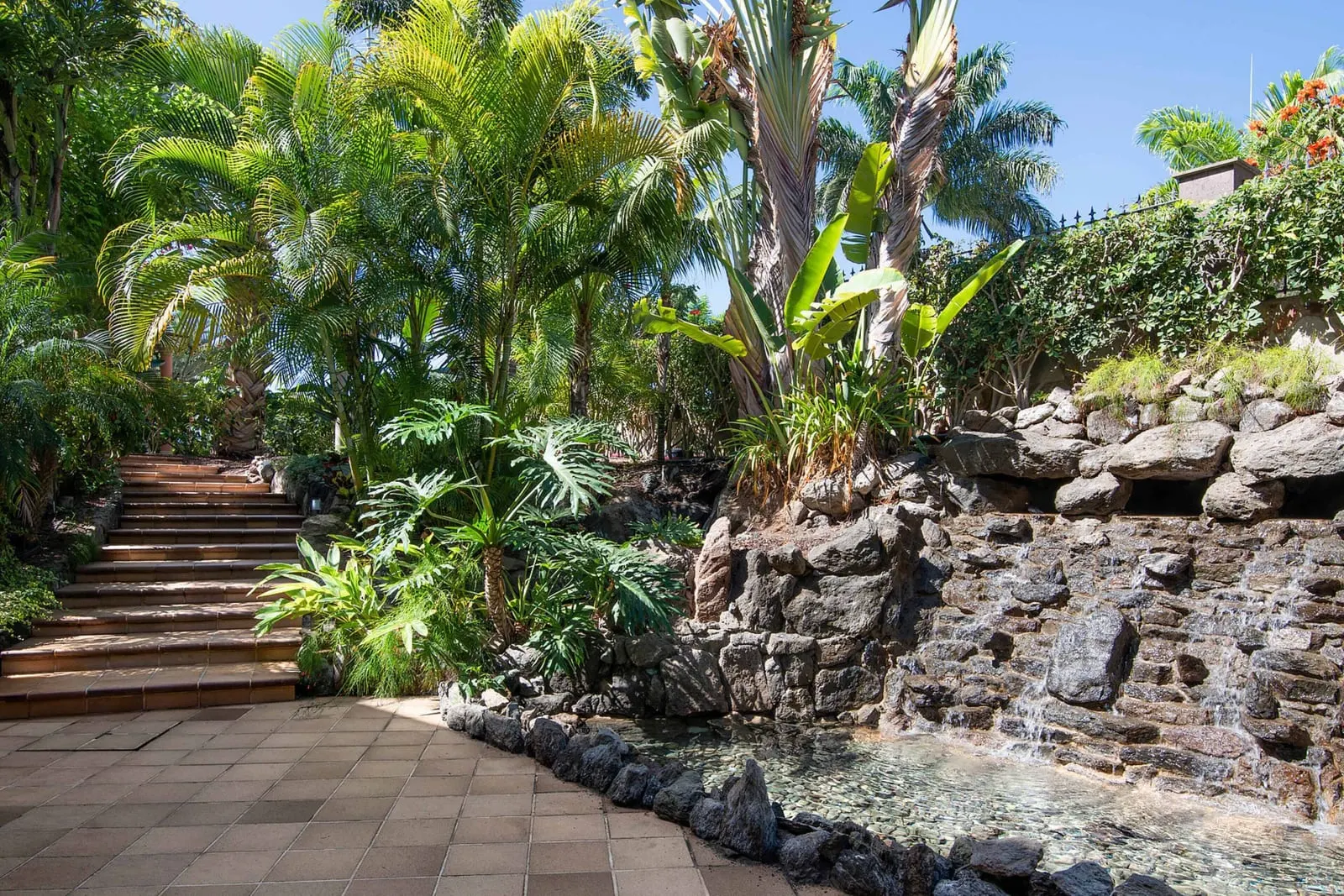Hotel Cordial Mogán Playa: A waterfall beside steps in the gardens