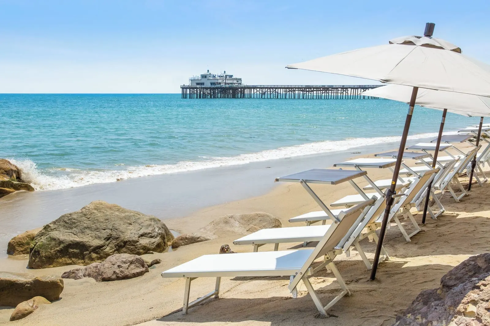 Malibu Beach Inn: Chairs and umbrellas on the sand at low tide