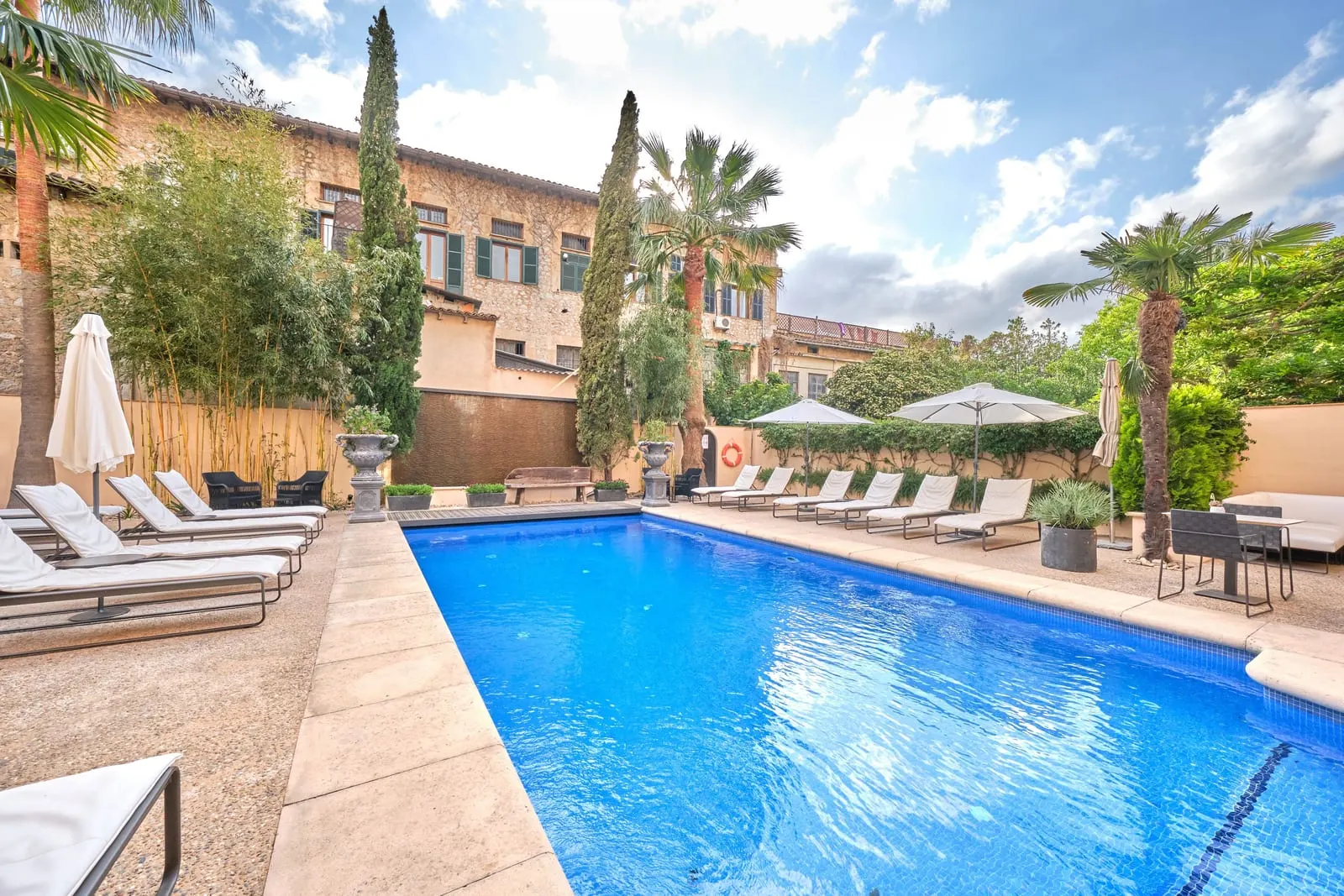 L'Avenida Hotel: The courtyard pool under palms and cypresses