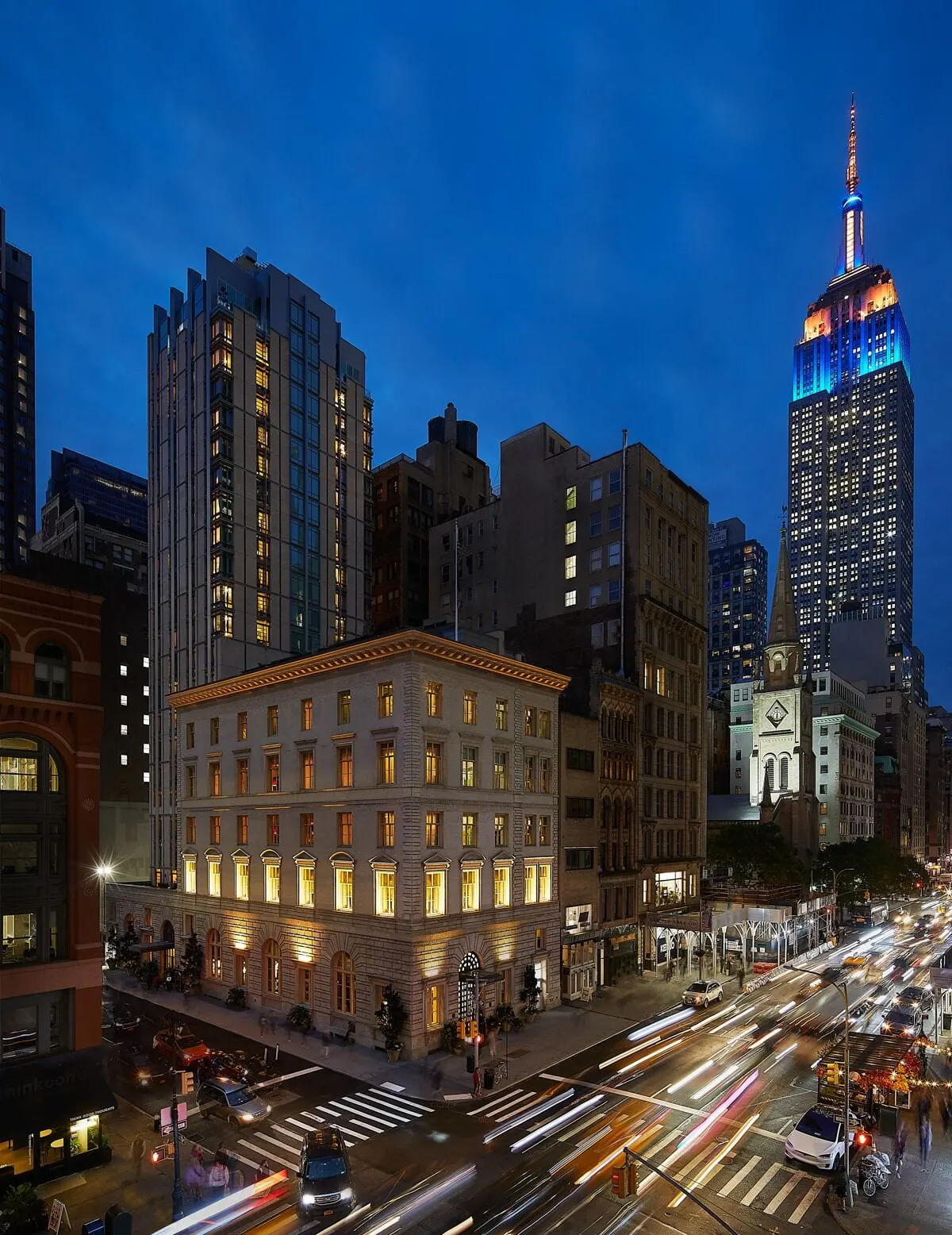 The Fifth Avenue Hotel: The 1907 bank on Fifth Avenue at dusk, the Empire State Building behind