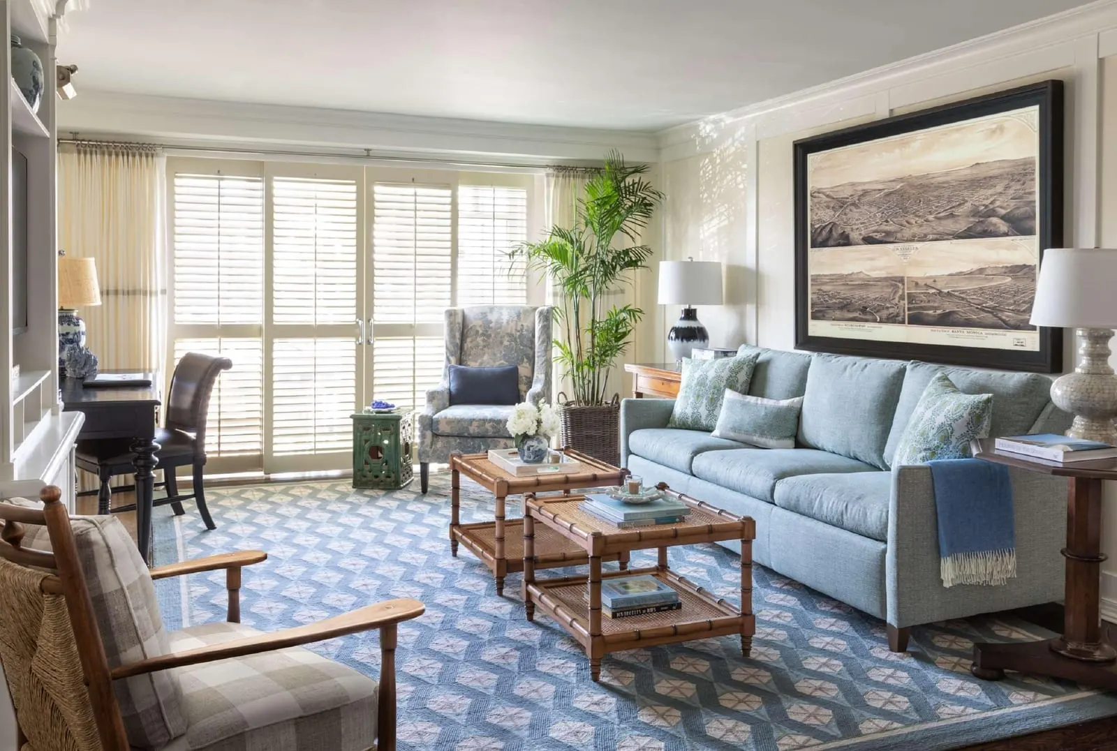 Santa Monica Suite im Shutters on the Beach: ein Wohnbereich mit einem hellblauen Sofa unter einer großen gerahmten antiken Landkarte, zwei Sesseln, einem Schreibtisch und Glastüren mit Fensterläden