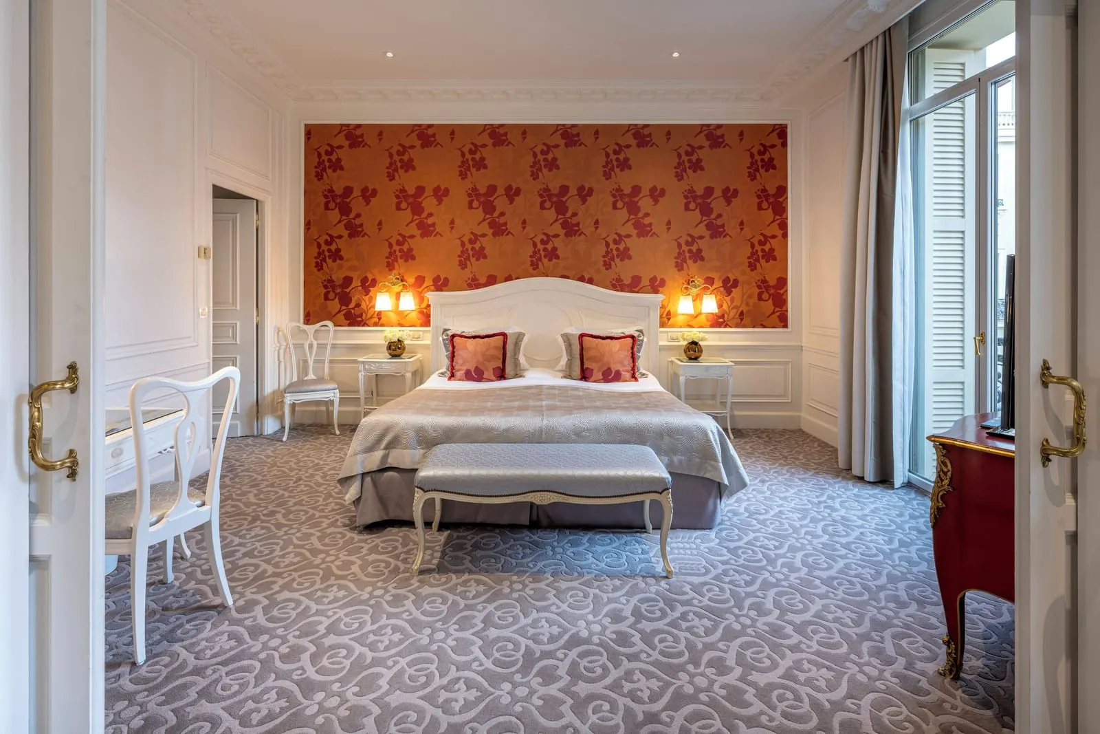 Suite with city or courtyard view at Hôtel Hermitage Monte-Carlo: the bedroom with a red floral panel behind the bed