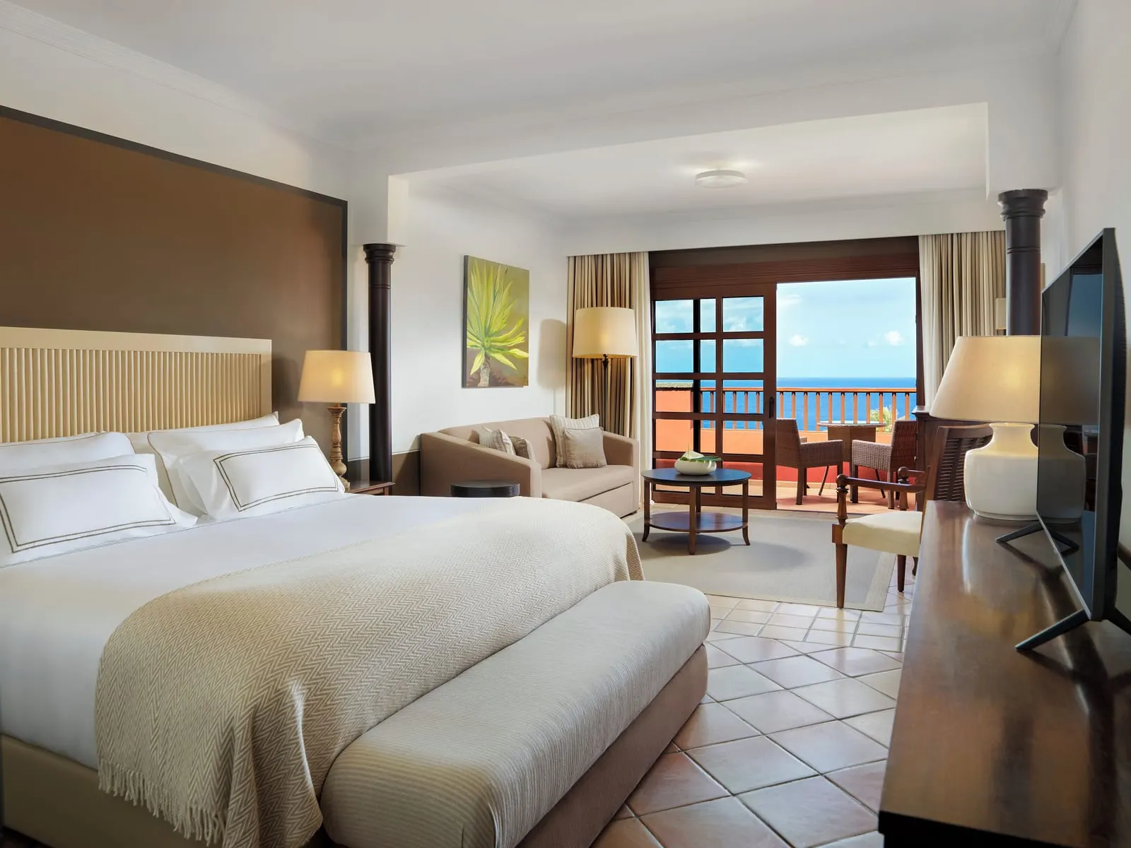 Singular Junior Suite Sea View with Panoramic Terrace at Hacienda del Conde: the bed, a sofa and doors to the terrace