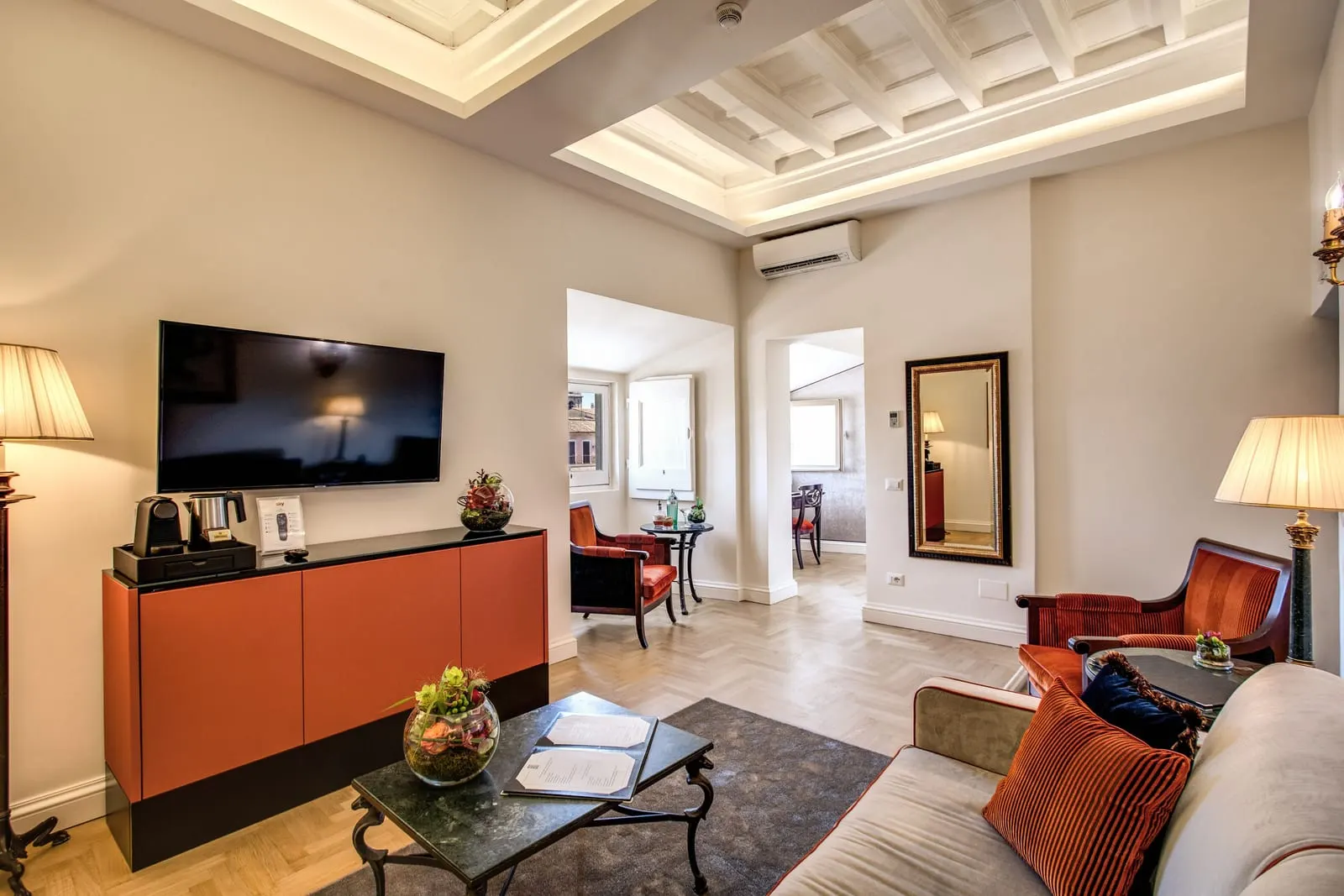 Deluxe Suite with View at Eitch Borromini Palazzo Pamphilj: the sitting room under a coffered ceiling, with a sofa, armchairs and a TV