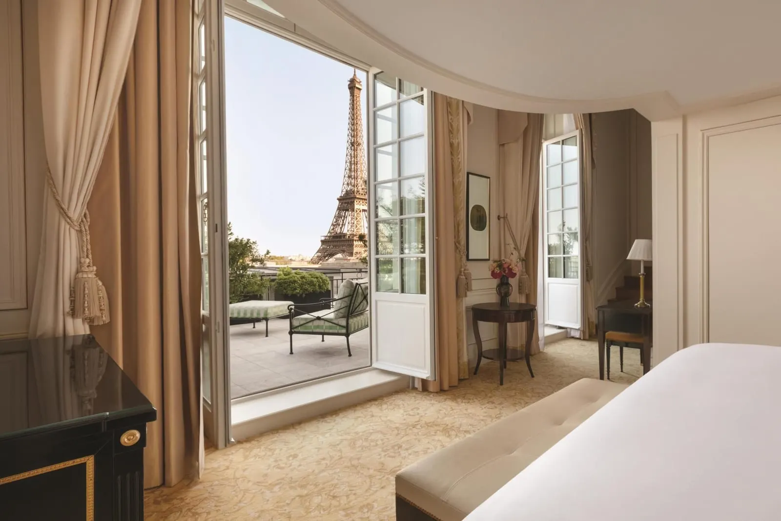 Duplex Terrace Eiffel View Suite at Shangri-La Paris: the bedroom, with French windows open onto the furnished terrace and the Eiffel Tower beyond