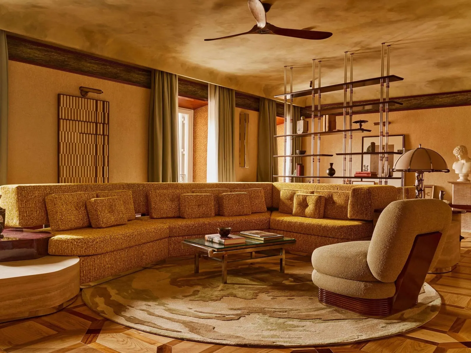 Orient Express Suite at Orient Express La Minerva: the living room with a long curved sofa, an armchair and glass shelving