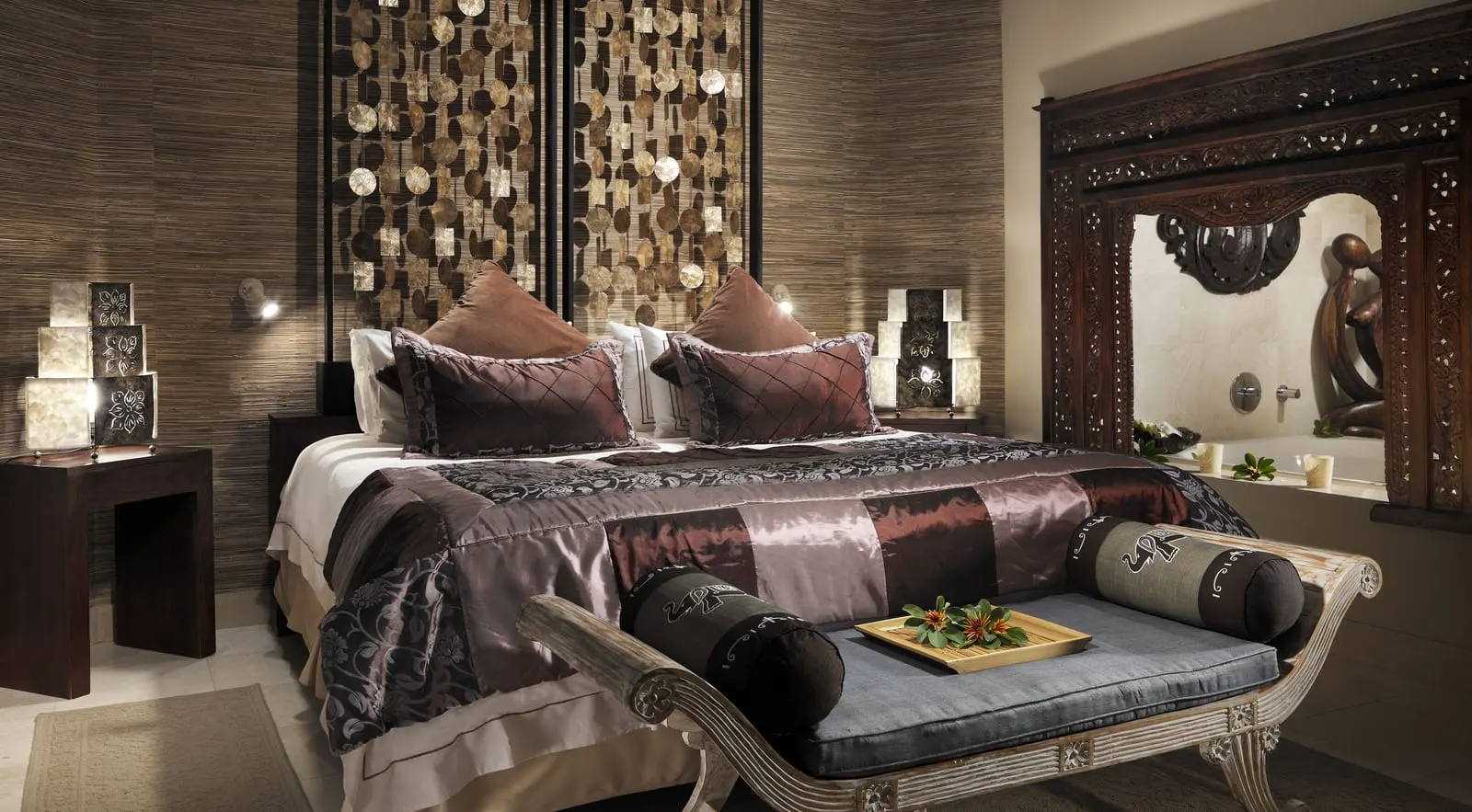 Majestic Villa at Royal Garden Villas: the bedroom, with a satin bedspread, a daybed at its foot and a carved wooden frame