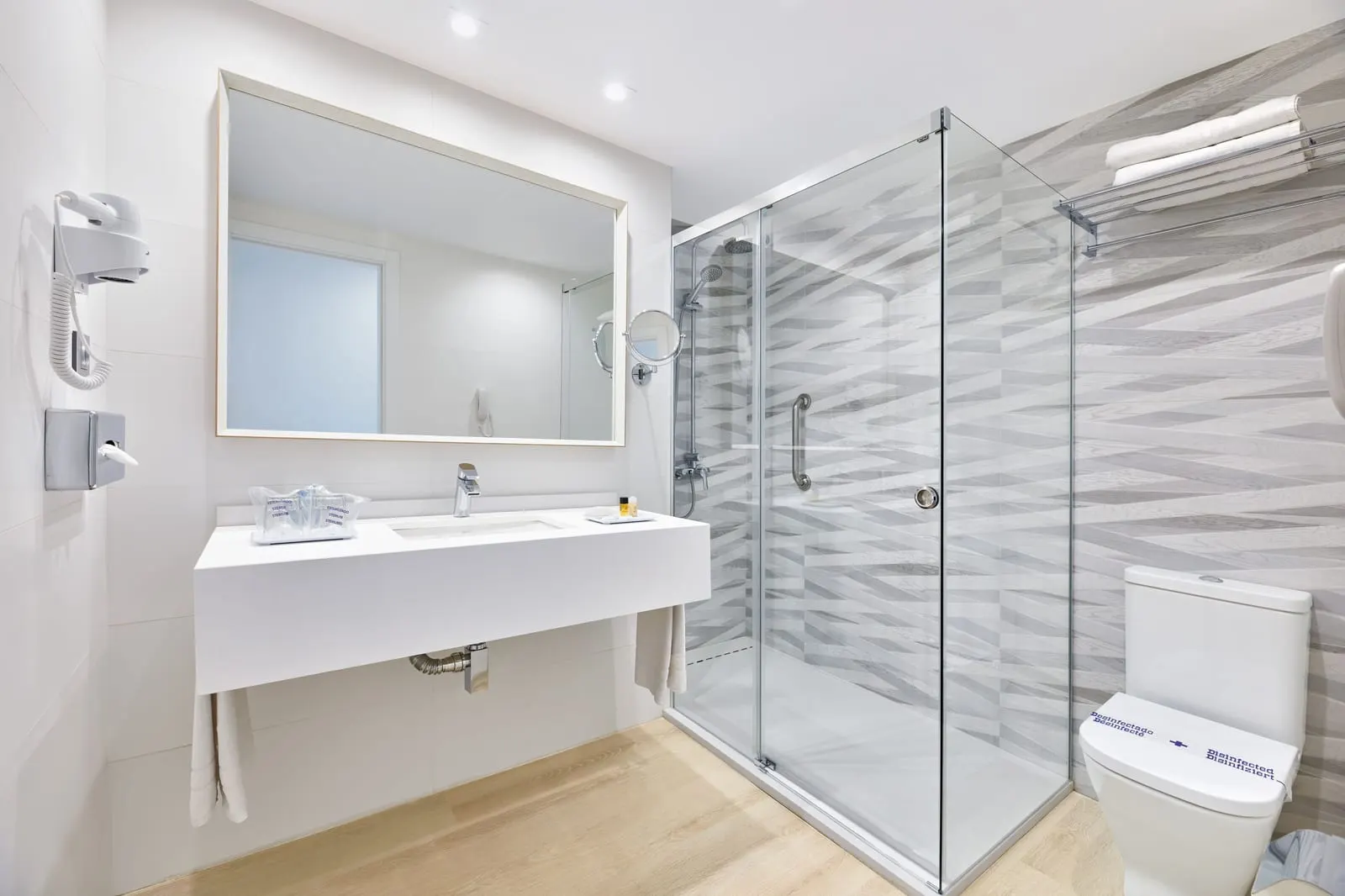 Double Room Sea View at Hotel Lancelot: a white bathroom with a glass shower screen and a wide basin under a large mirror