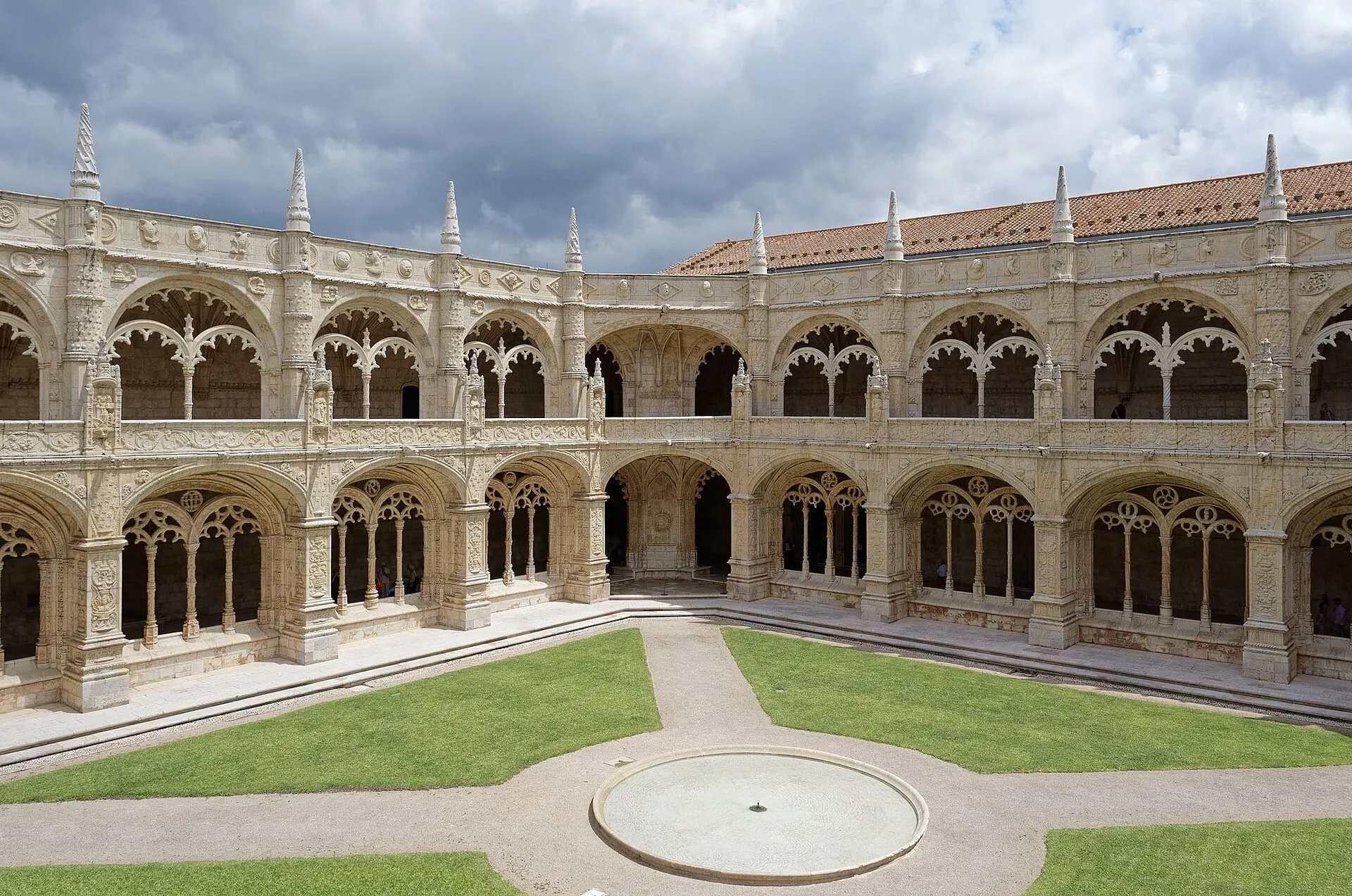 The two-storey Manueline cloister of the Jerónimos Monastery in Belém, its carved arches around a lawn