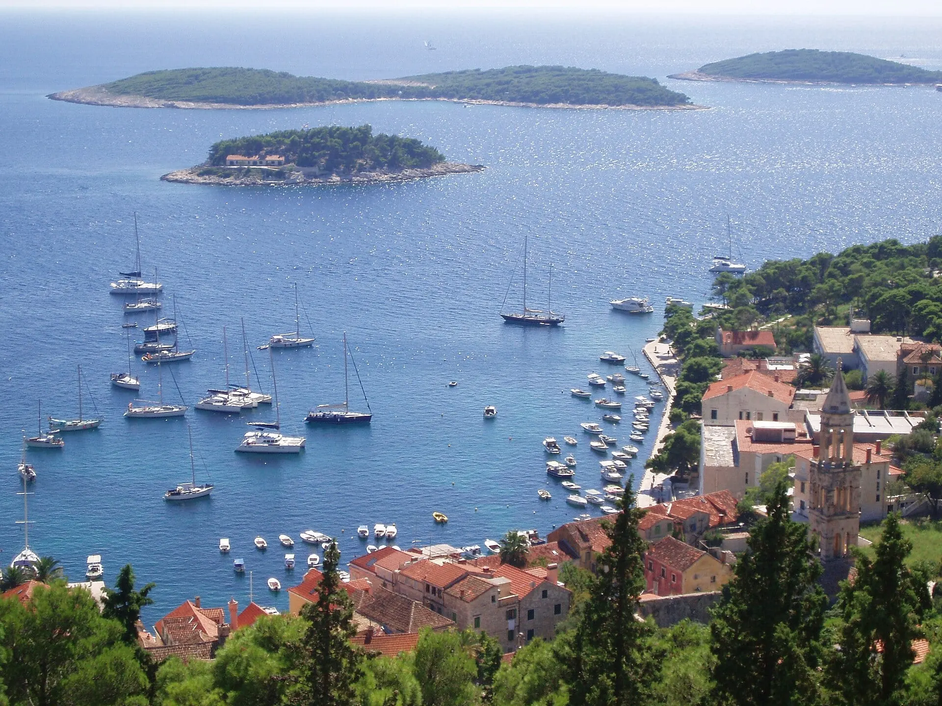 Yachts anchored in the blue bay of Hvar town with the Pakleni islands offshore.