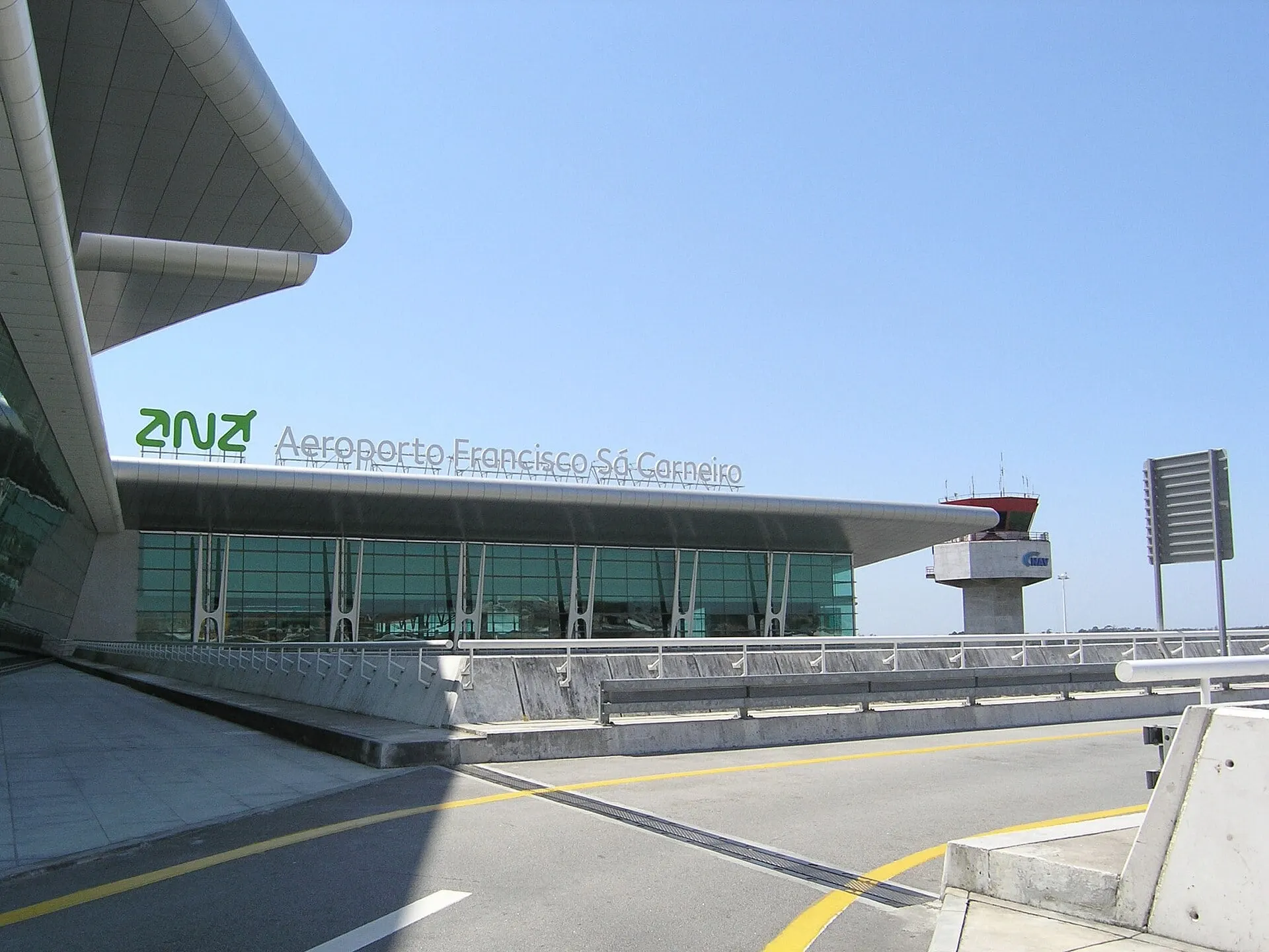 The glass front of the terminal at Porto Francisco Sá Carneiro Airport, with the control tower beyond