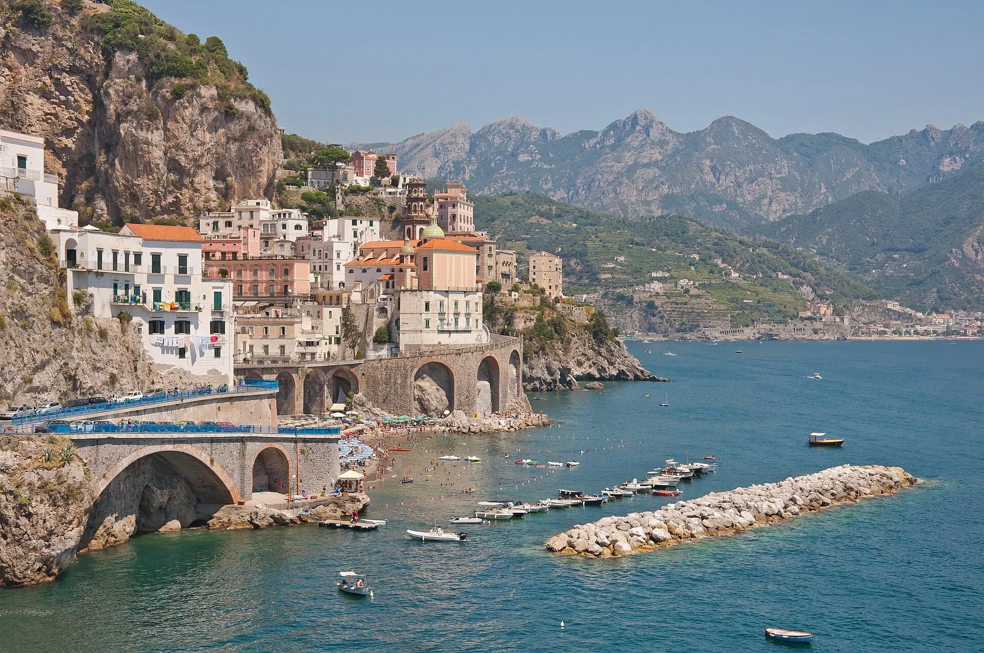 Atrani on the Amalfi Coast, houses stacked above a blue bay with mountains behind