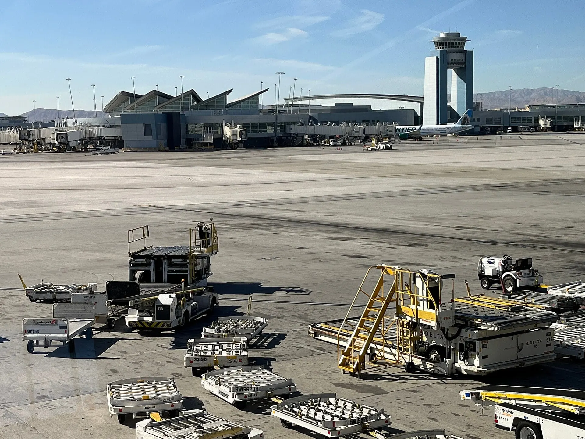 The apron, terminal and control tower at Harry Reid International, with desert mountains beyond