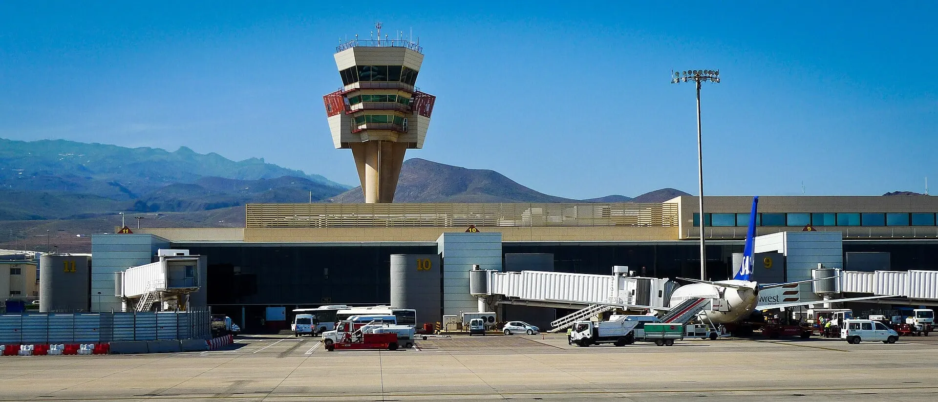 The control tower and boarding gates at Gran Canaria Airport, with the island's mountains behind