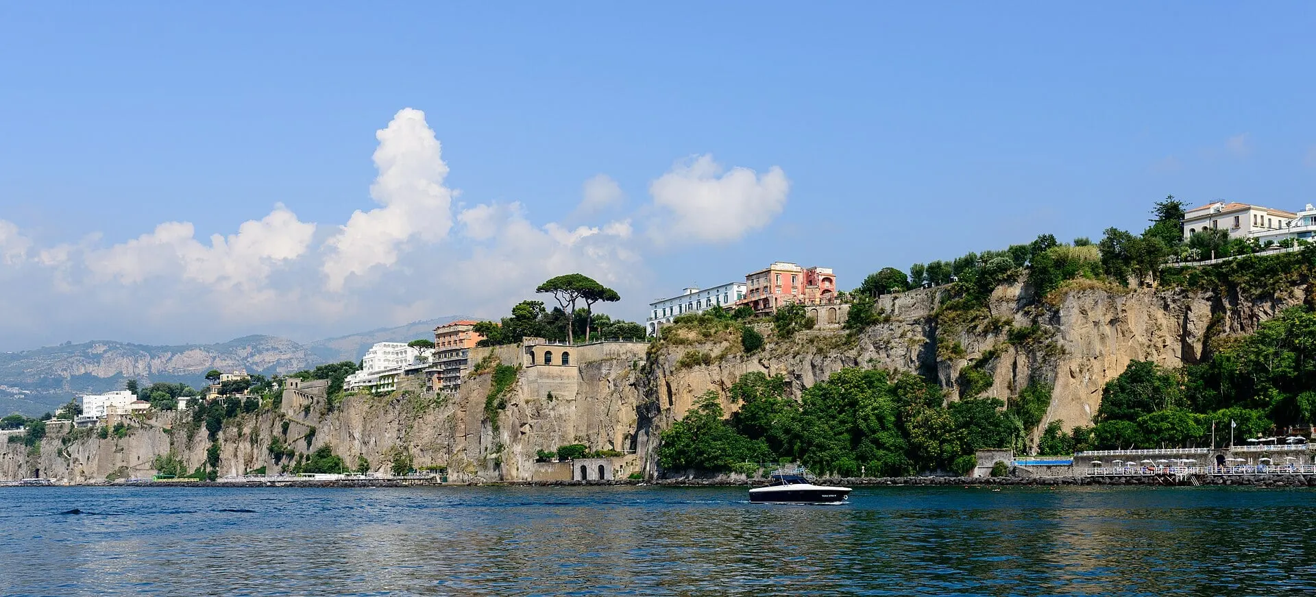 The cliffs of Sorrento rising from a blue sea under a bright sky