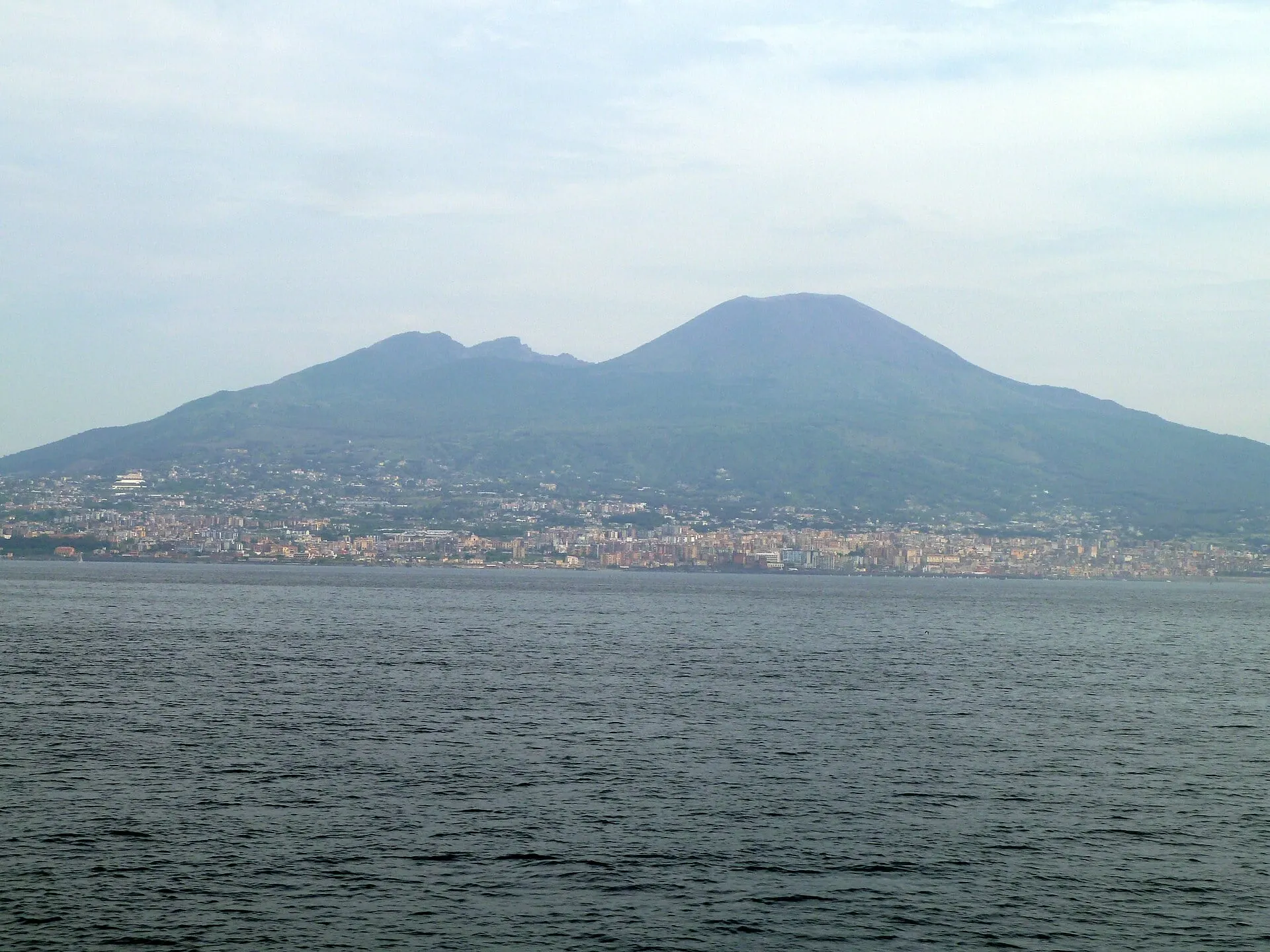 Vesuvius rising above the towns on the shore of the Bay of Naples, seen from the water