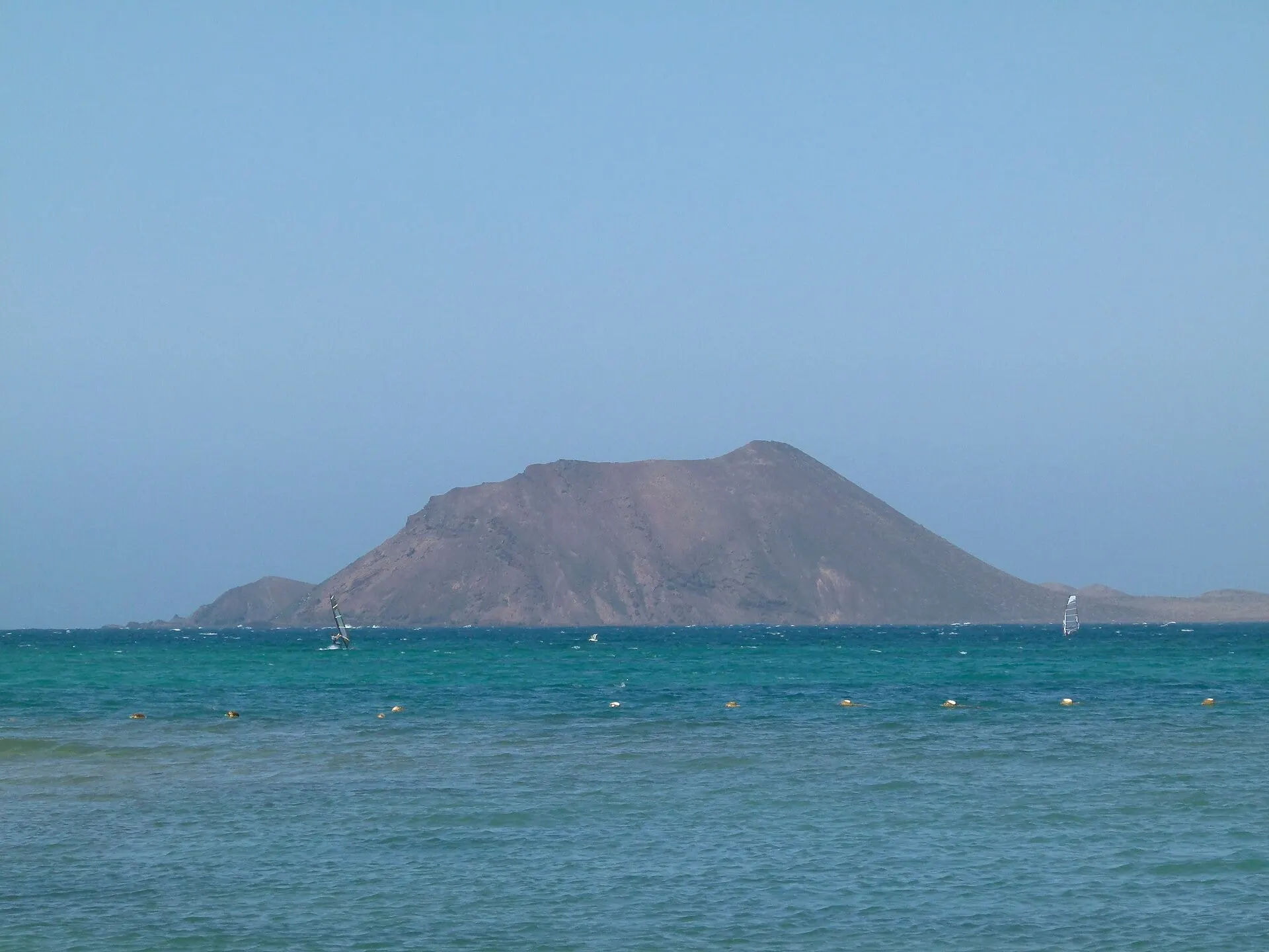 The volcanic cone of Isla de Lobos seen across the water from Corralejo beach