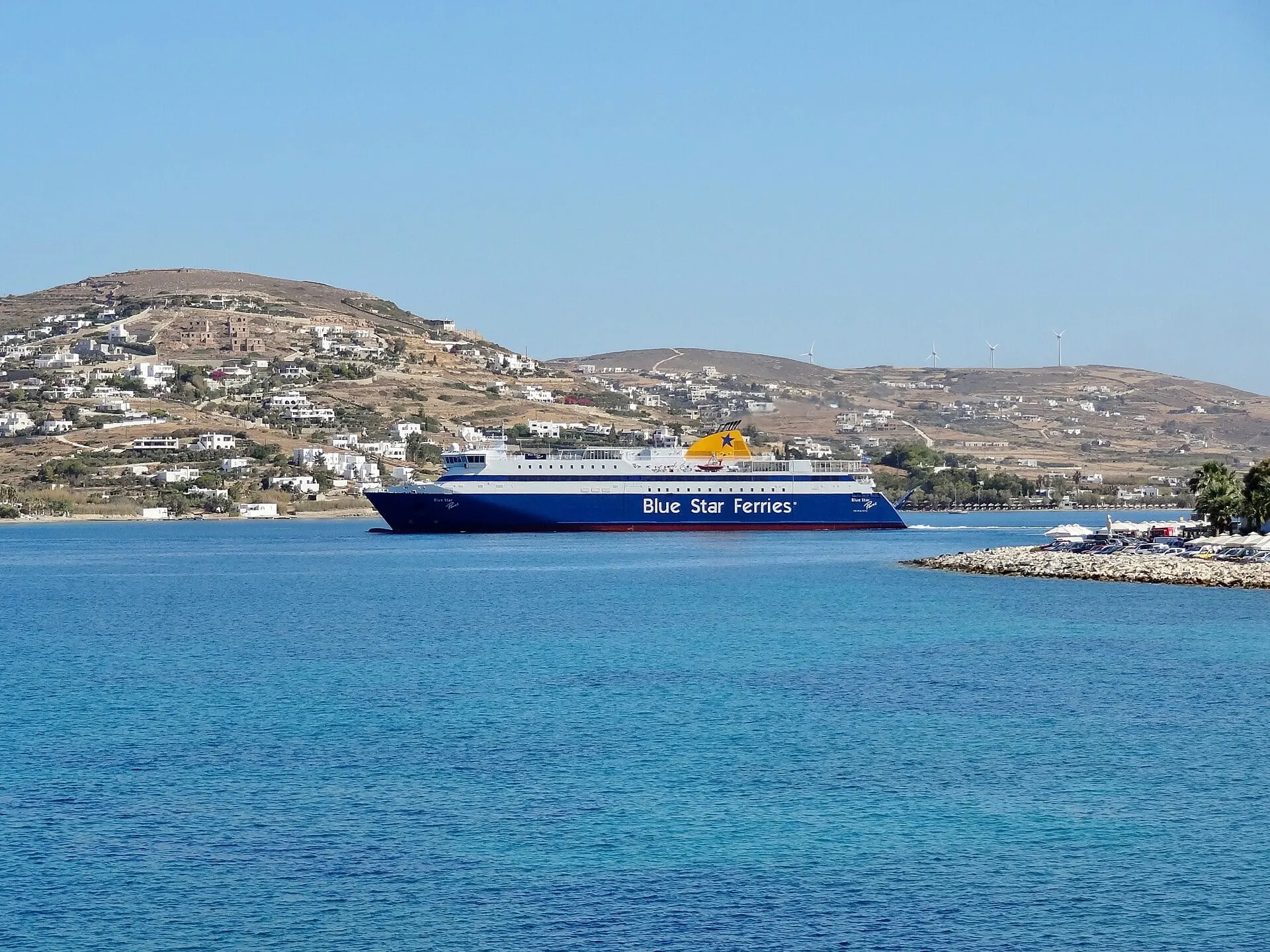 Die Fähre Blue Star Paros fährt in die Bucht von Parikia auf Paros ein.