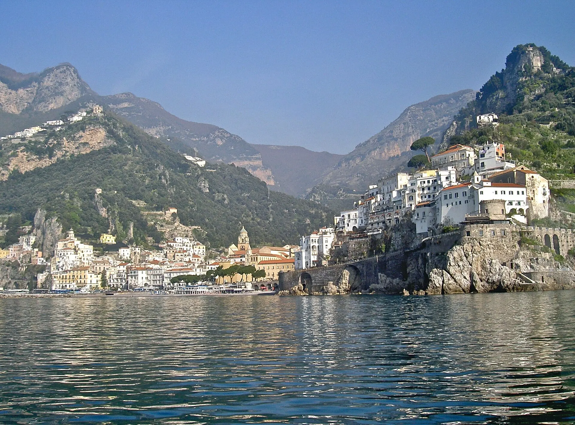 Amalfi seen across the water below the mountains, where the journey ends