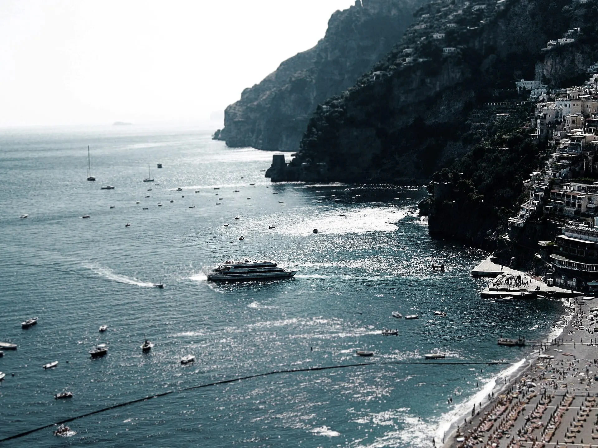 A ferry leaving Positano past the cliffs and beach