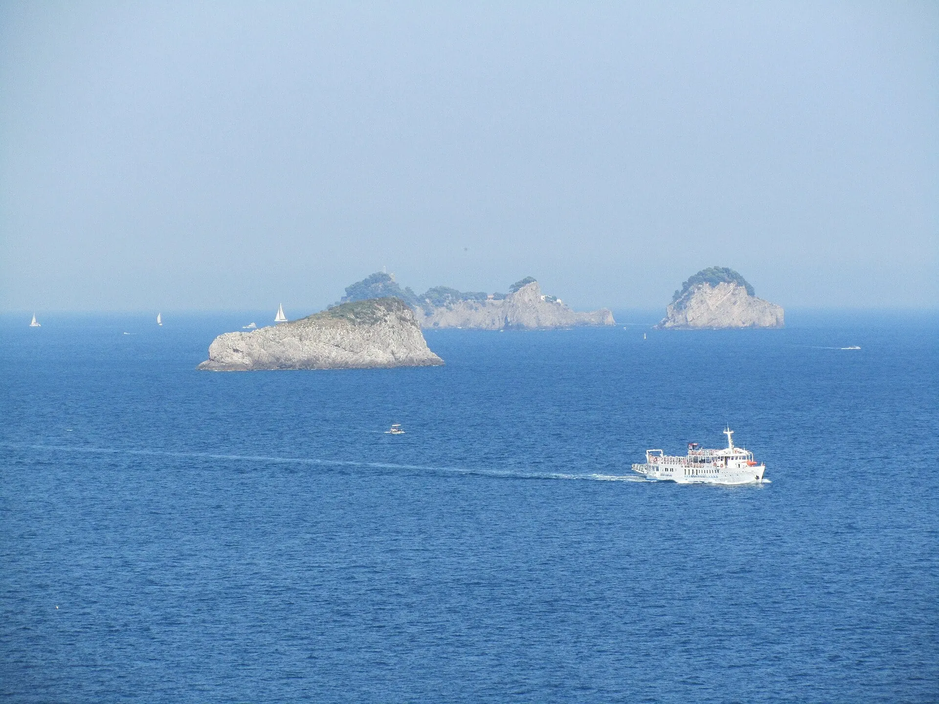 A boat crossing the sea in front of the Li Galli islets