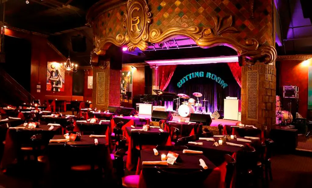 The Cutting Roomのメインルーム。金色のモザイクのアーチの下、ステージの前にキャンドルを置いたディナーのテーブルが並ぶ